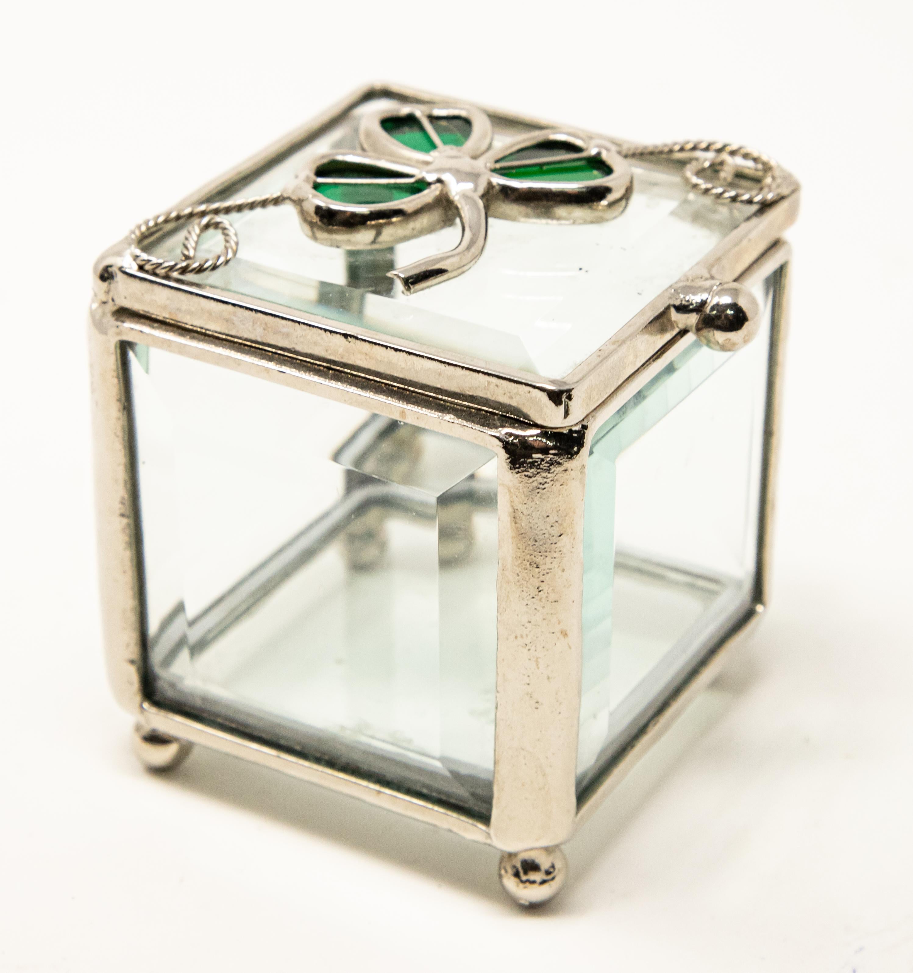 Offering this unmatchable sterling silver glass box with clover. Handcrafted sterling are the main structure to this stunning glass box. Beveled glass makes up all the sides. Has four ball feet on bottom. The top has a crafted clover and green