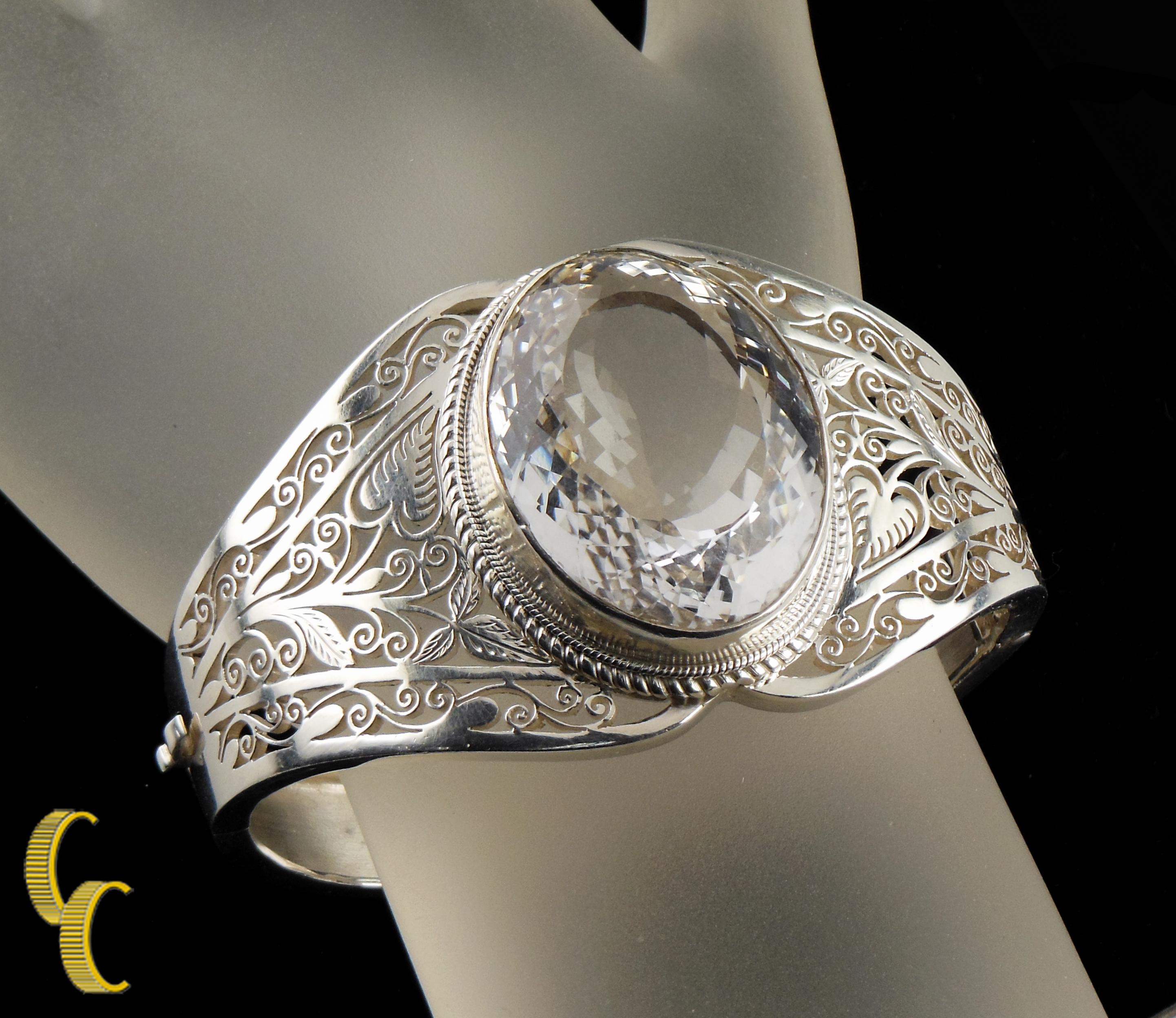 0.925 sterling silver bangle bracelet with leaf and vine design.
Colorless spinel set in the center.
Intricate vine and leaf pattern.
A beautiful piece in excellent condition.
Wrist Fit: 7 inches.
Spinel: 35 x 28 mm.
Weight: 64.6 grams.