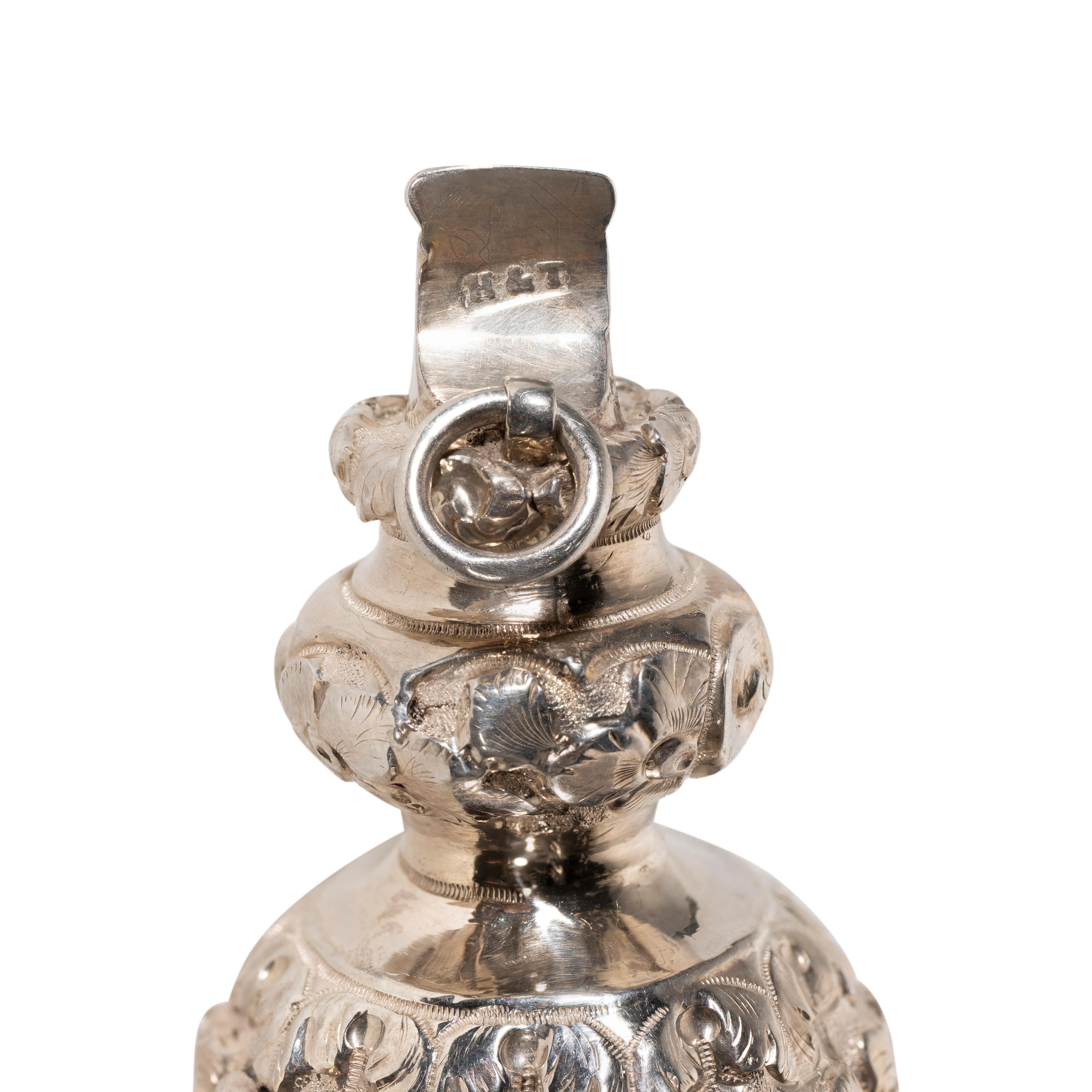 Exceptional antique Victorian sterling silver baby rattle and whistle has a bulbous shaped form. The surface of the tiered body is embellished with impressive embossed leaf decoration. The impressive antique silver rattle is fitted with seven