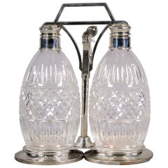 Juego de tántalo de dos botellas de plata de ley y cristal, Siglo XX
