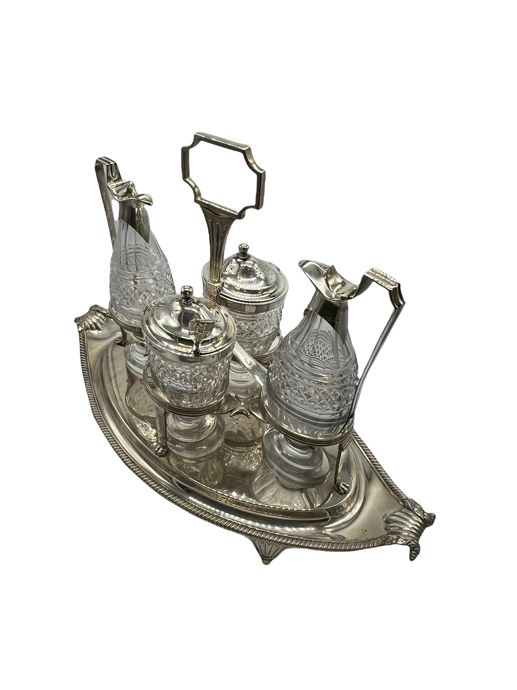 Sterling silver and cut-glass cruet set by Paul Storr. A pair of cruets and two footed condiment jars, crafted of finely cut glass mounted in silver, are held securely on a distinctive handled tray adorned with an intricate egg-and-dart trim,