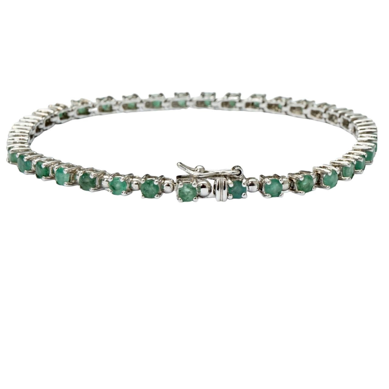Beautiful sterling silver tennis bracelet with a safety catch, set with a row of pale green emeralds. Measuring length 19.3 cm / 7.6 inches by width 2.5 mm / .1 inch, and depth 3.5 mm / .13 inch.

This is a classic tennis bracelet set with emeralds.
