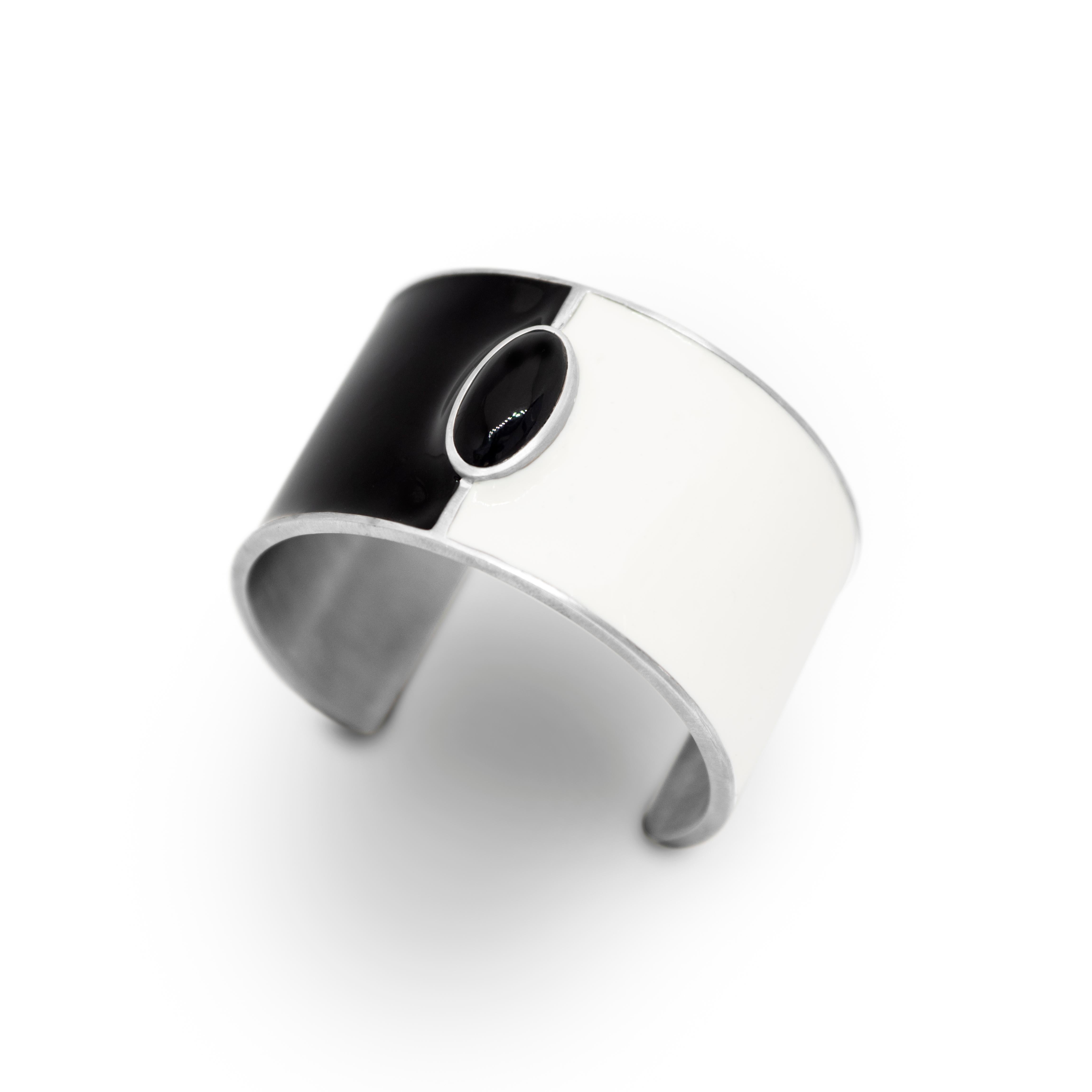 Genderless cuff bracelet in satin sterling silver, black and white enamel, set with black onyx cabochon. A geometric, minimalistic, androgynous, piece with healing properties. The black onyx is a powerful stone that releases negativity from a
