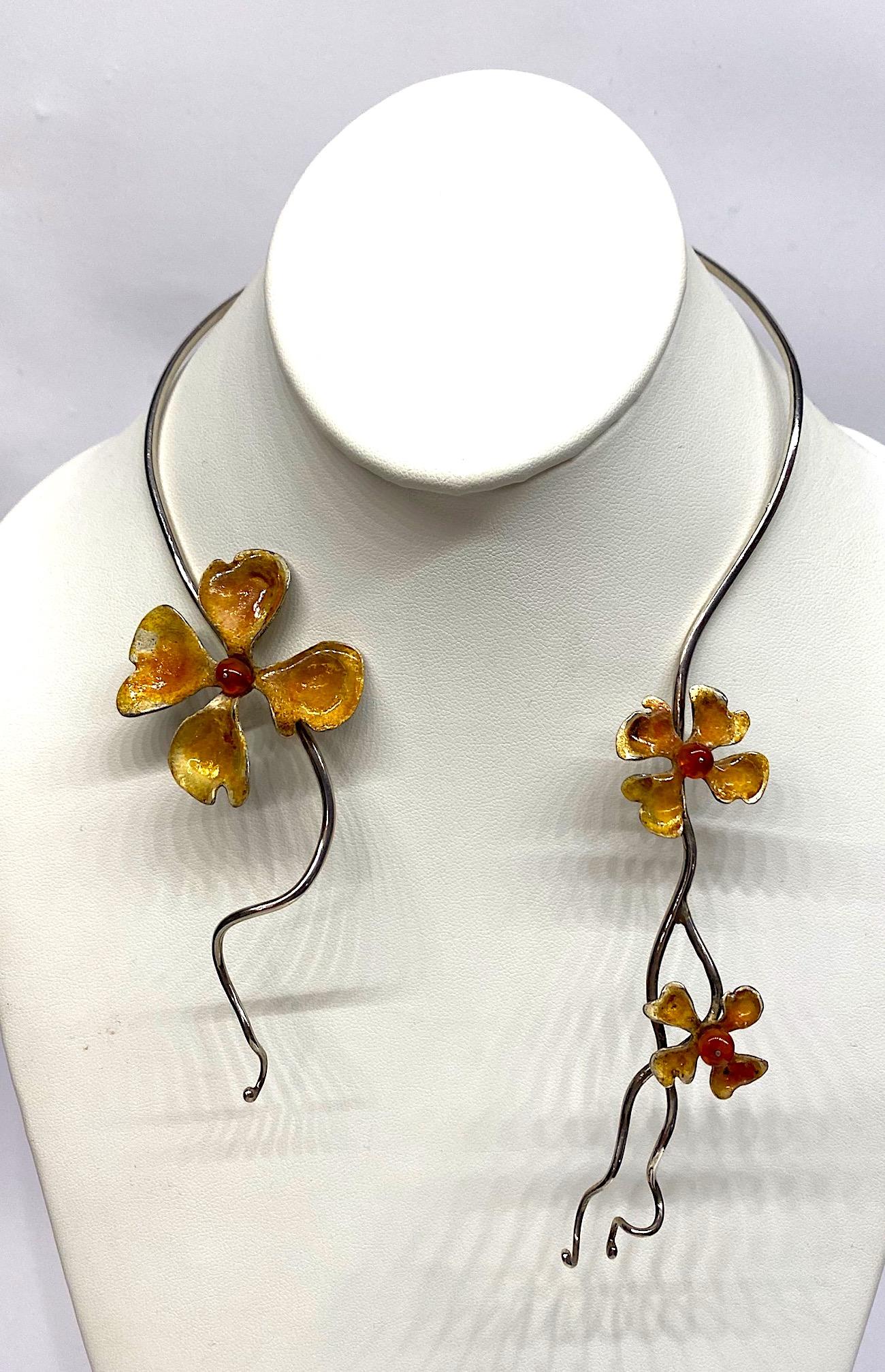 Starre Halskette mit drei emaillierten Blumen, um 1970/80 hergestellt. der 3 mm dicke Sterlingsilberdraht ist so gebogen, dass er um den Hals passt. Jedes Ende ist gewellt und verjüngt sich anmutig auf etwas mehr als 1 mm und endet in einer kleinen