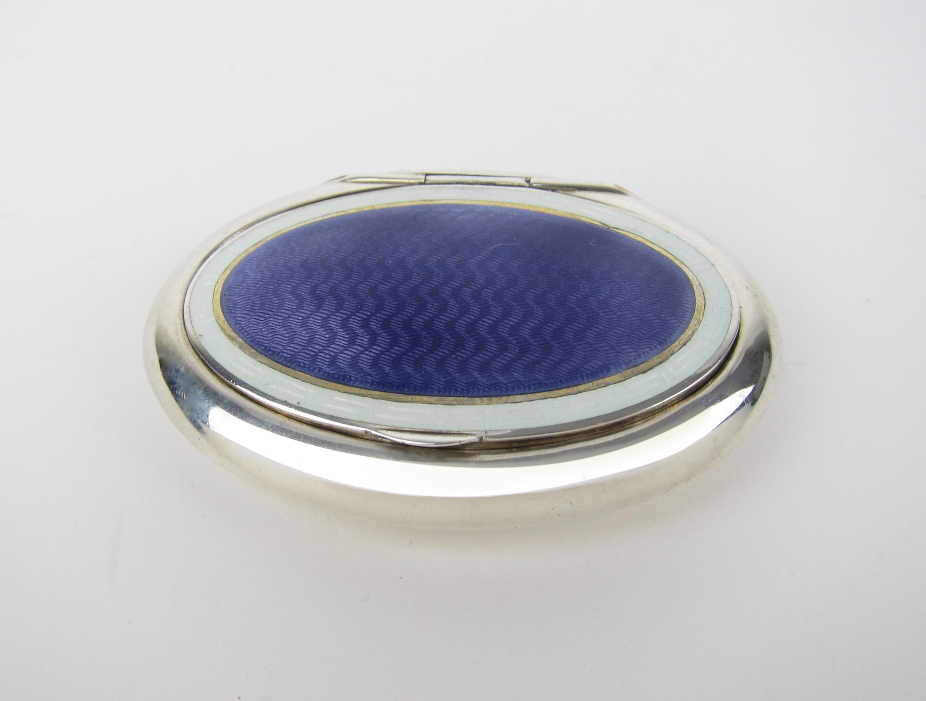 An antique English sterling silver and enamel box of oval cushion form with a hinged lid and gilt interior by Charles Edwin Turner of Birmingham, date marked for 1910. The Guilloche enameled lid is a field of rich purple over an engine-turned