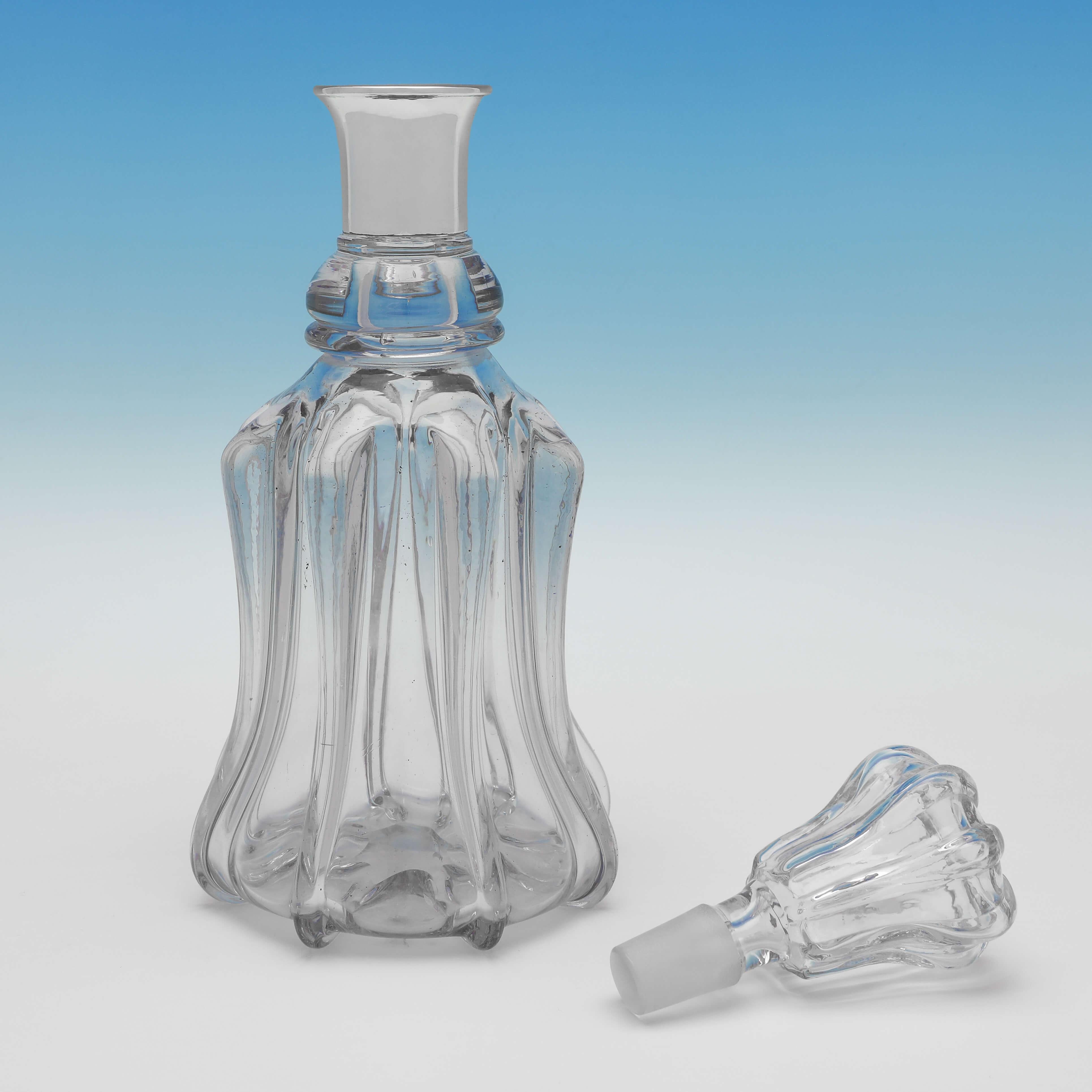 Hallmarked in Sheffield in 1956 by Mappin & Webb, this handsome, Mid-Century Modern, glass and sterling silver decanter, has a lobed glass body and stopper, and a silver collar. The decanter measures 11