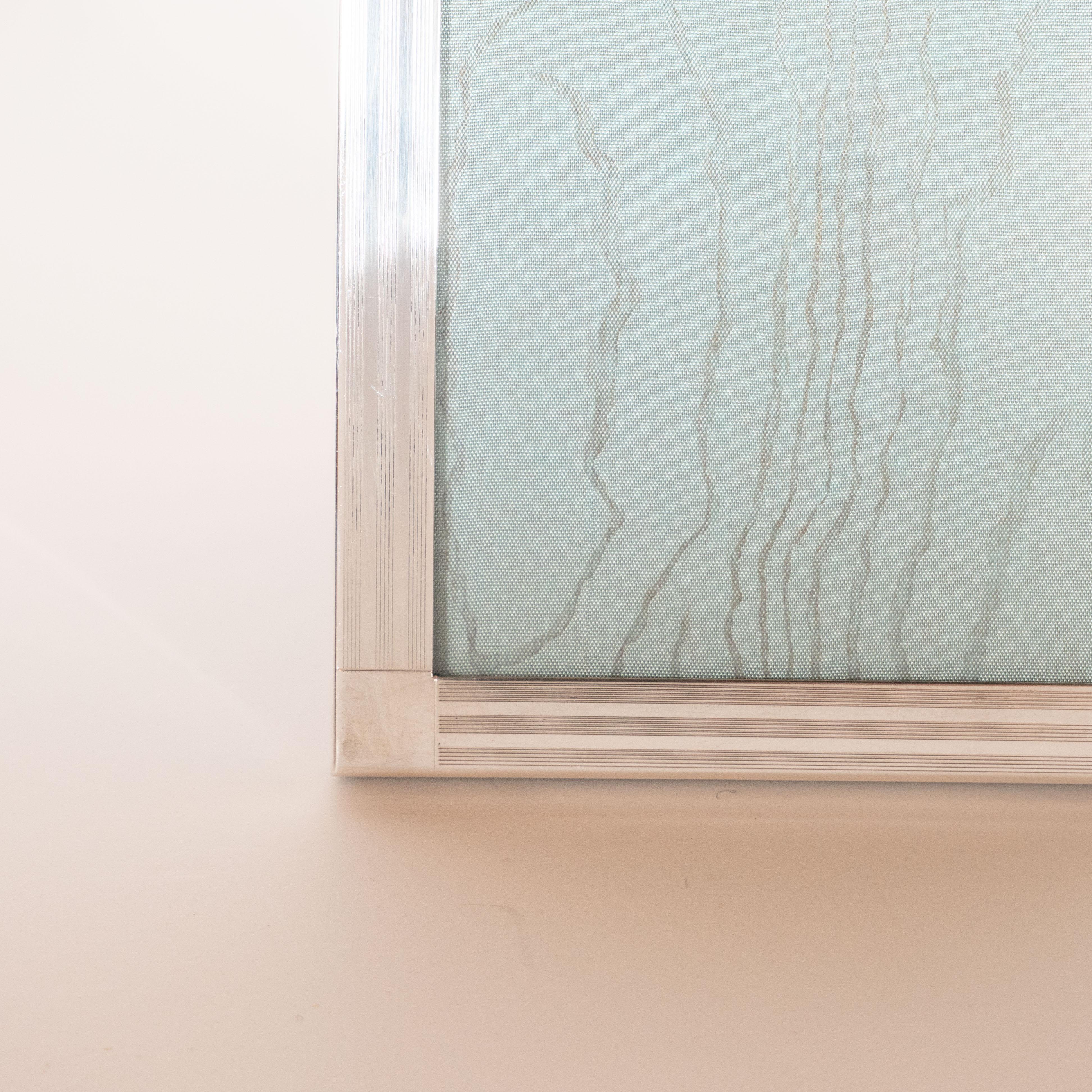 This elegant Art Deco style picture frame was realized by Tiffany & Co., one of America's most storied luxury brands, most renowned for their sterling silver objects, circa 1970. Executed in sterling silver, it features a engine turned geometric