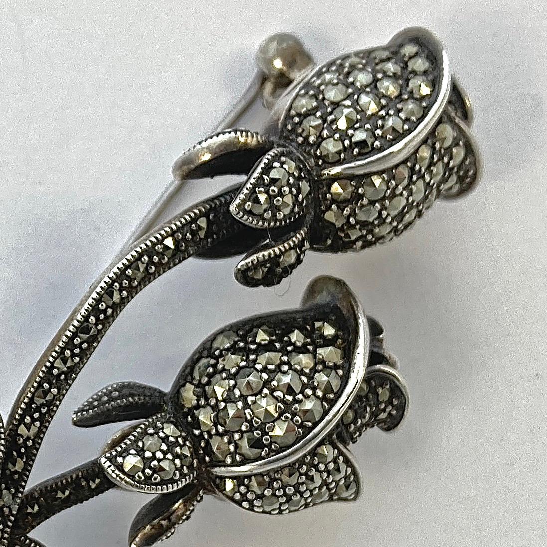 Beautiful sterling silver brooch featuring a double rosebud design, and embellished with marcasites and silver decoration. Measuring length 6cm / 2.36 inches. It is in very good condition, we have given the brooch a light clean.

This is a vintage