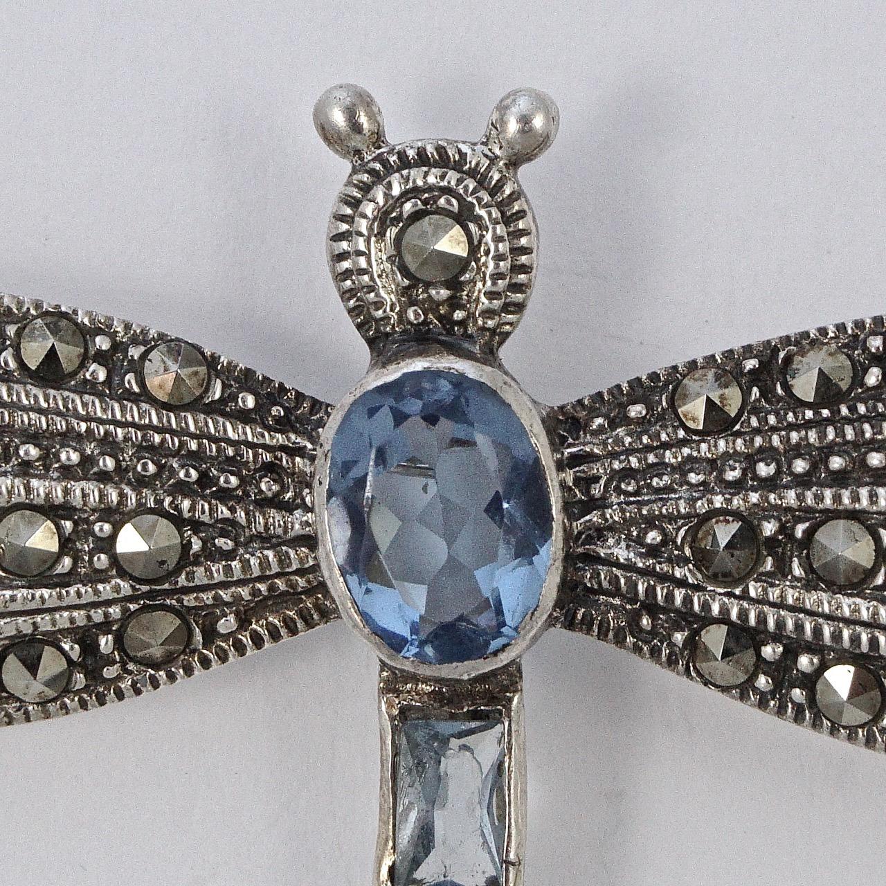 Beautiful detailed sterling silver dragonfly brooch, embellished with marcasites and set with blue glass stones. Measuring length 4.5cm / 1.77 inches by width 5.8cm / 2.28 inches. The brooch is stamped with a leopards head and 925, and the date