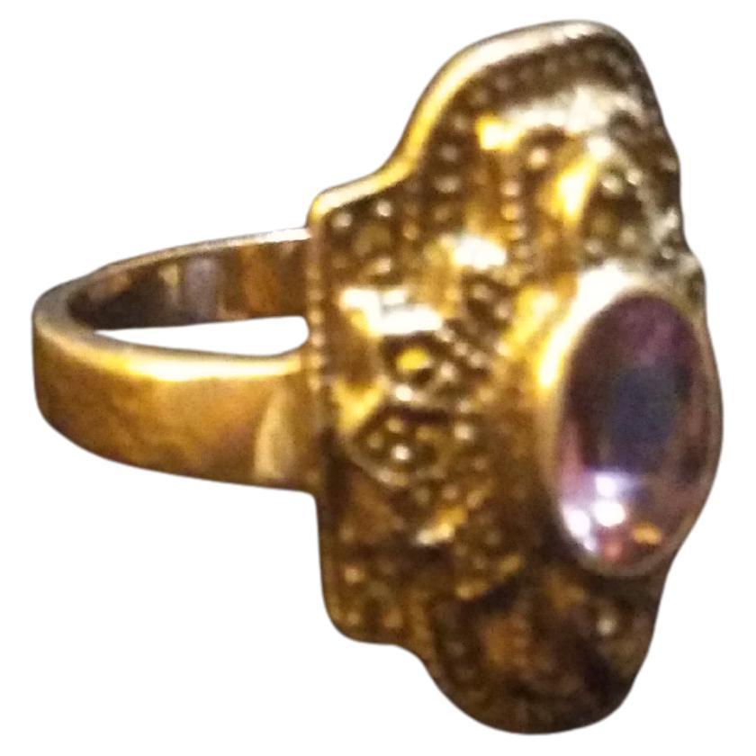 This is a size 8 sterling silver and marcasite 
ring. The ring has a beautiful amethyst center setting. The face has an oblong diamond shape that's intricately designed.


Ready to wear.