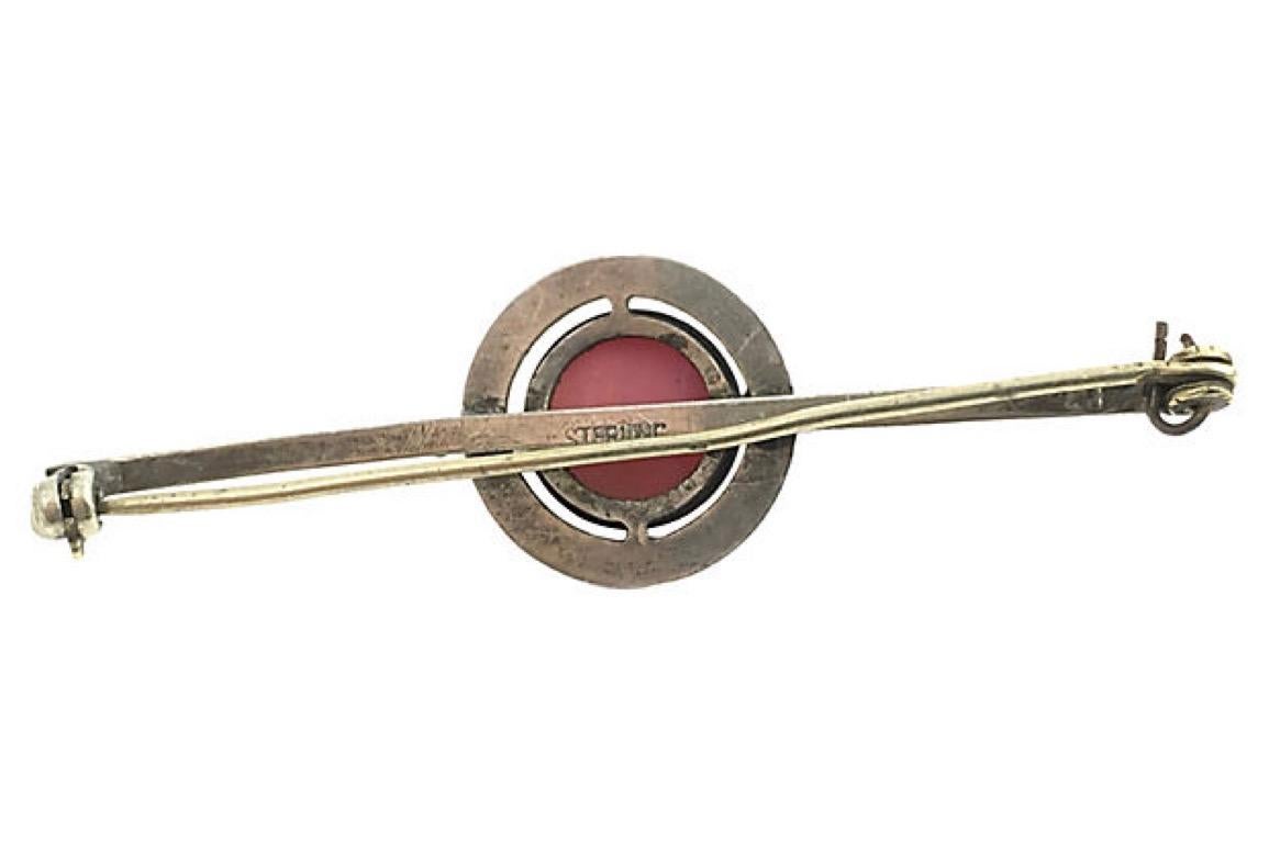 Bar pin brooch with pink cabochon plastic bead bezel set in a sterling vine frame with a Greek key design on the bar pin section. Marked: Sterling. Age wear, bent pin.