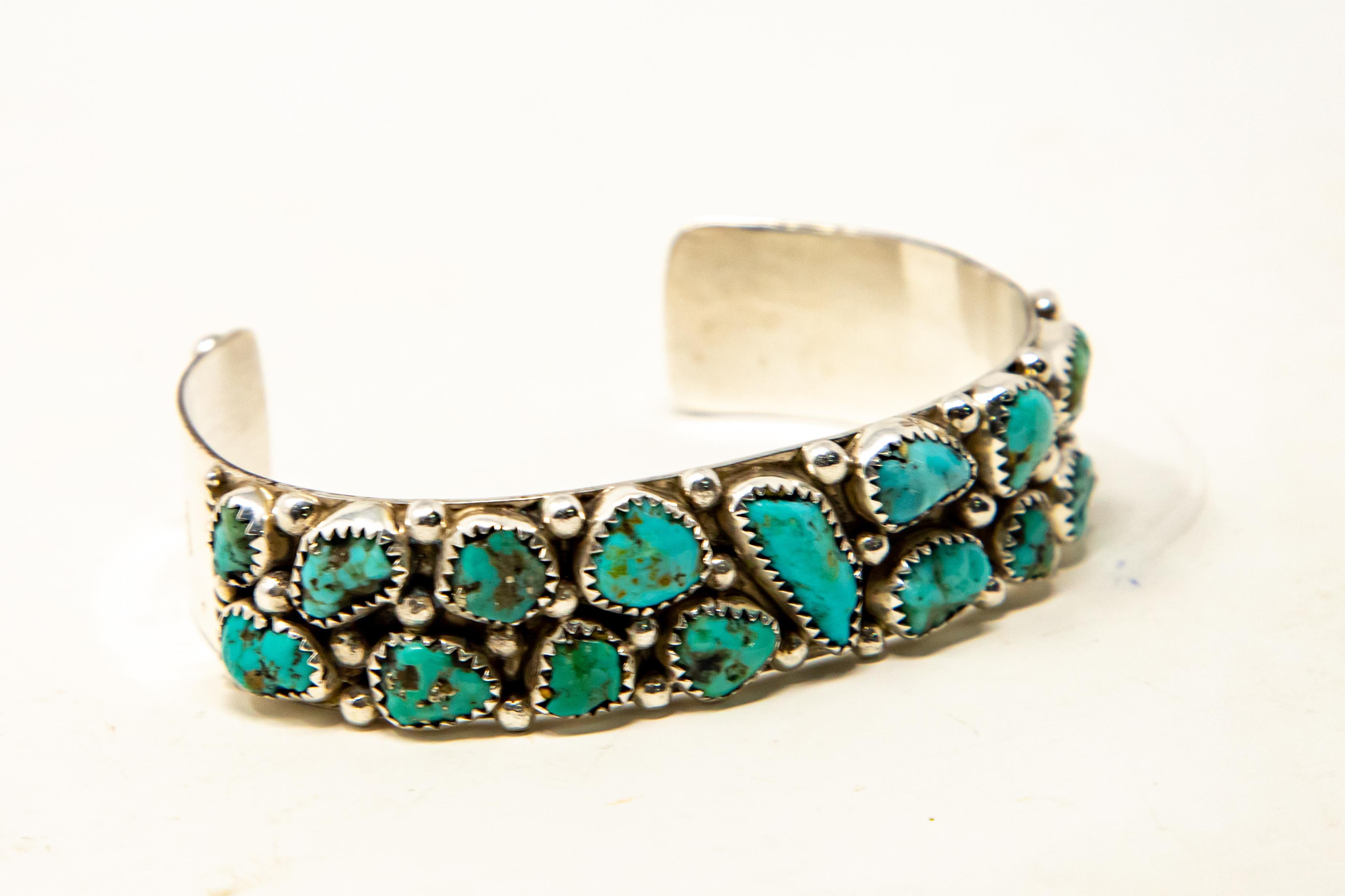 Offering this stunning sterling silver and turquoise cuff. Having seventeen stones set in sterling silver this one is a dazzler. On each end of the cuff is three balls, then going into the middle there is scrollwork and balls around all the