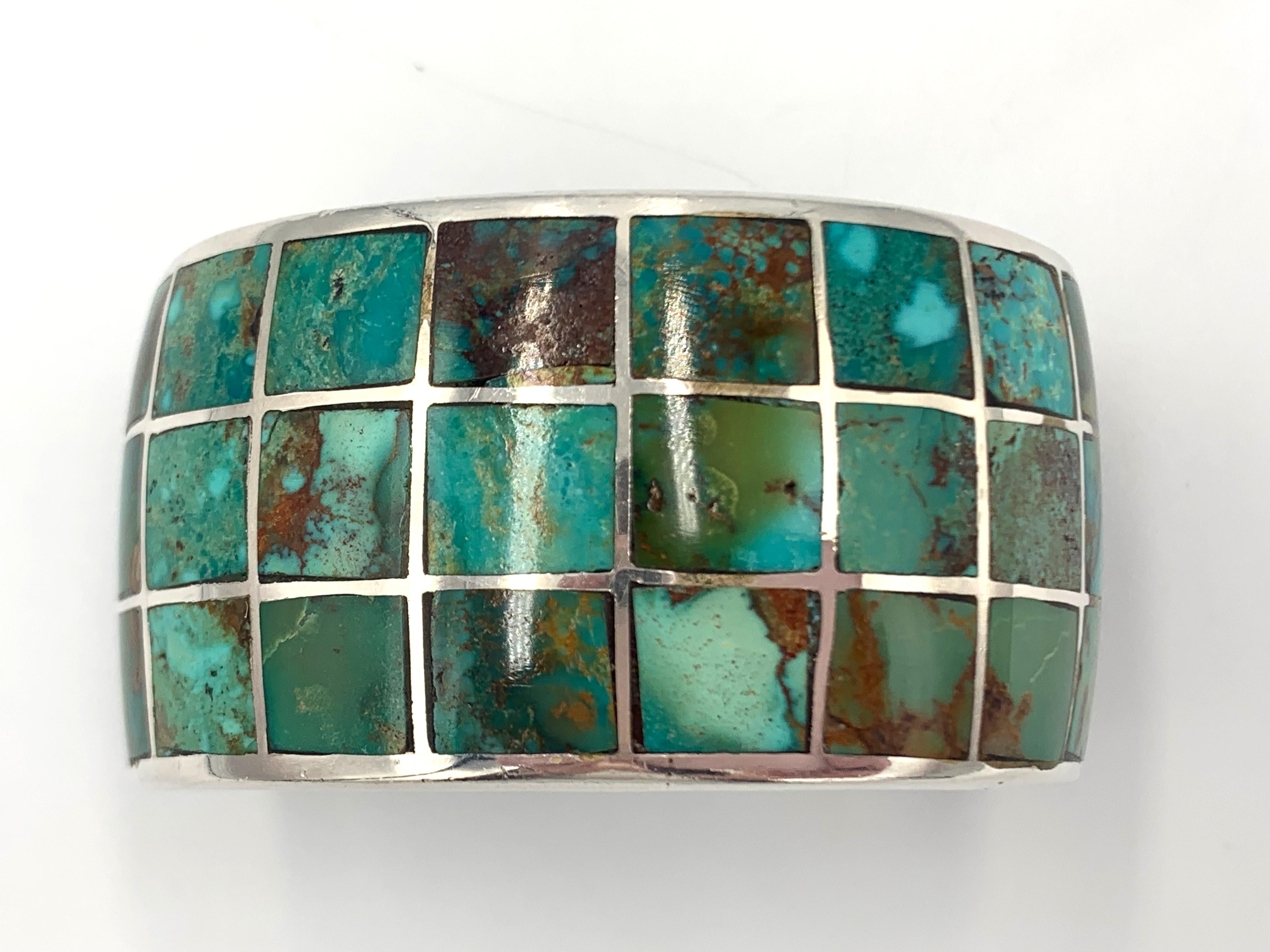 Sterling silver cuff with green turquoise channel inlay. Each piece of turquoise is custom cut to fit into silver channels, an exacting jewelry method. The cuff is 5 1/4” with a 1” gap. 

Gap: 1”
Total inside circumference: 6-1/4”
Hallmark: