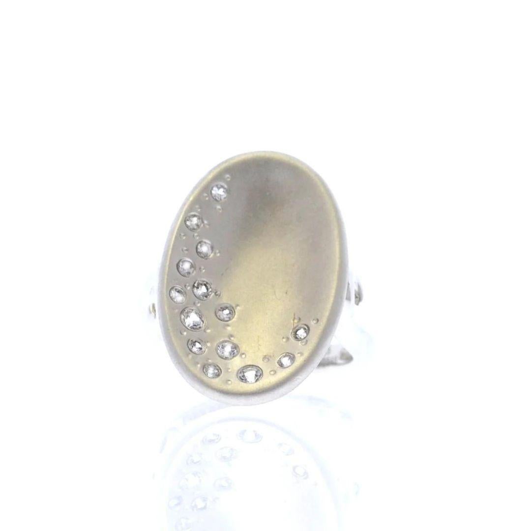 Elegant and unique, this one of a kind sterling silver ring is studded with genuine white sapphires along the edge of the concave top. Satin finish creates a softness to the curves. Rhodium plated for tarnish free maintenance.