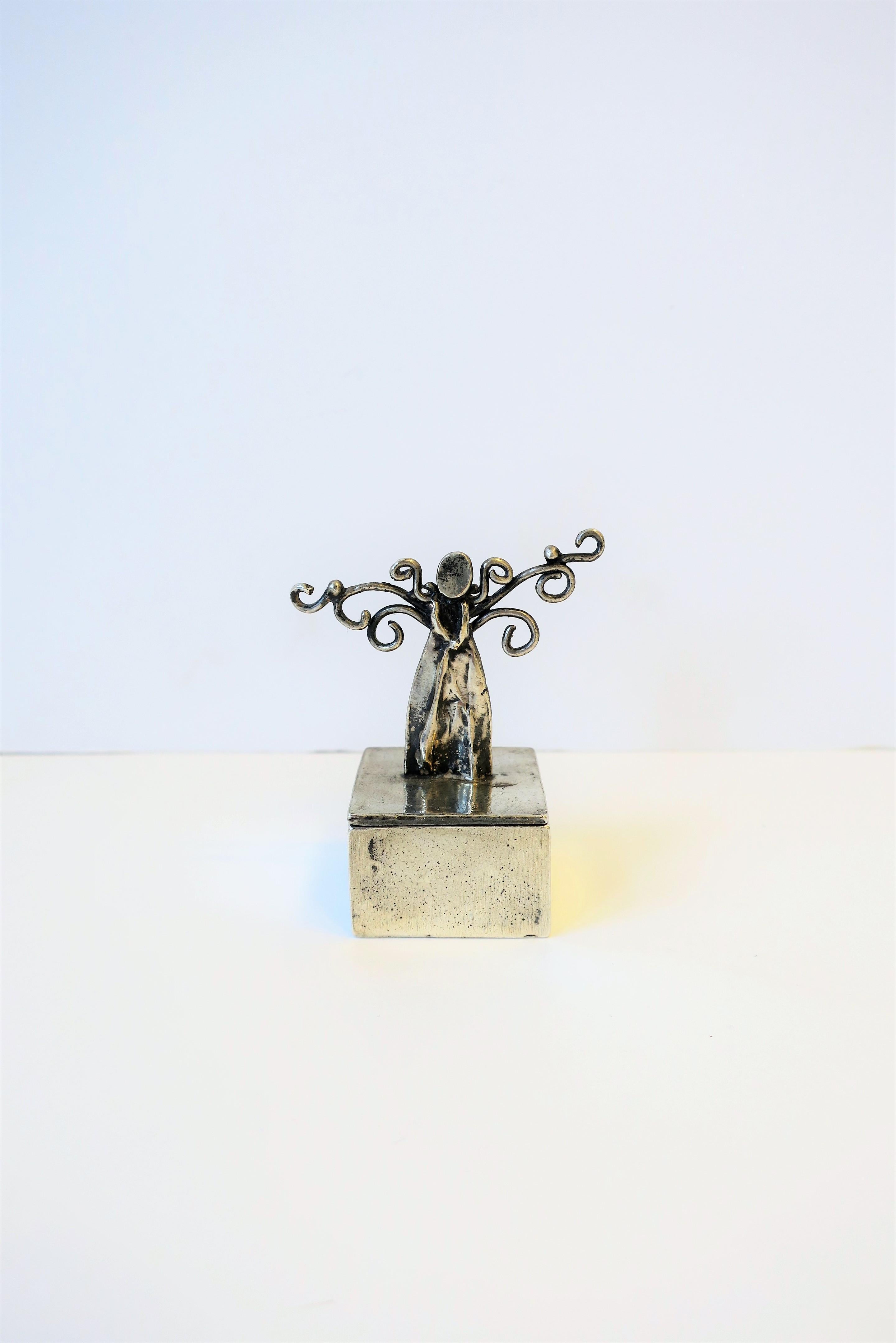 This is a very special, well made, handcrafted sterling silver 'Angel' box. Angel is featured standing on top of box lid in a dress with her arms/hands in front, beautiful wings on sides, and a 'heart' on her back. This is a beautiful piece that