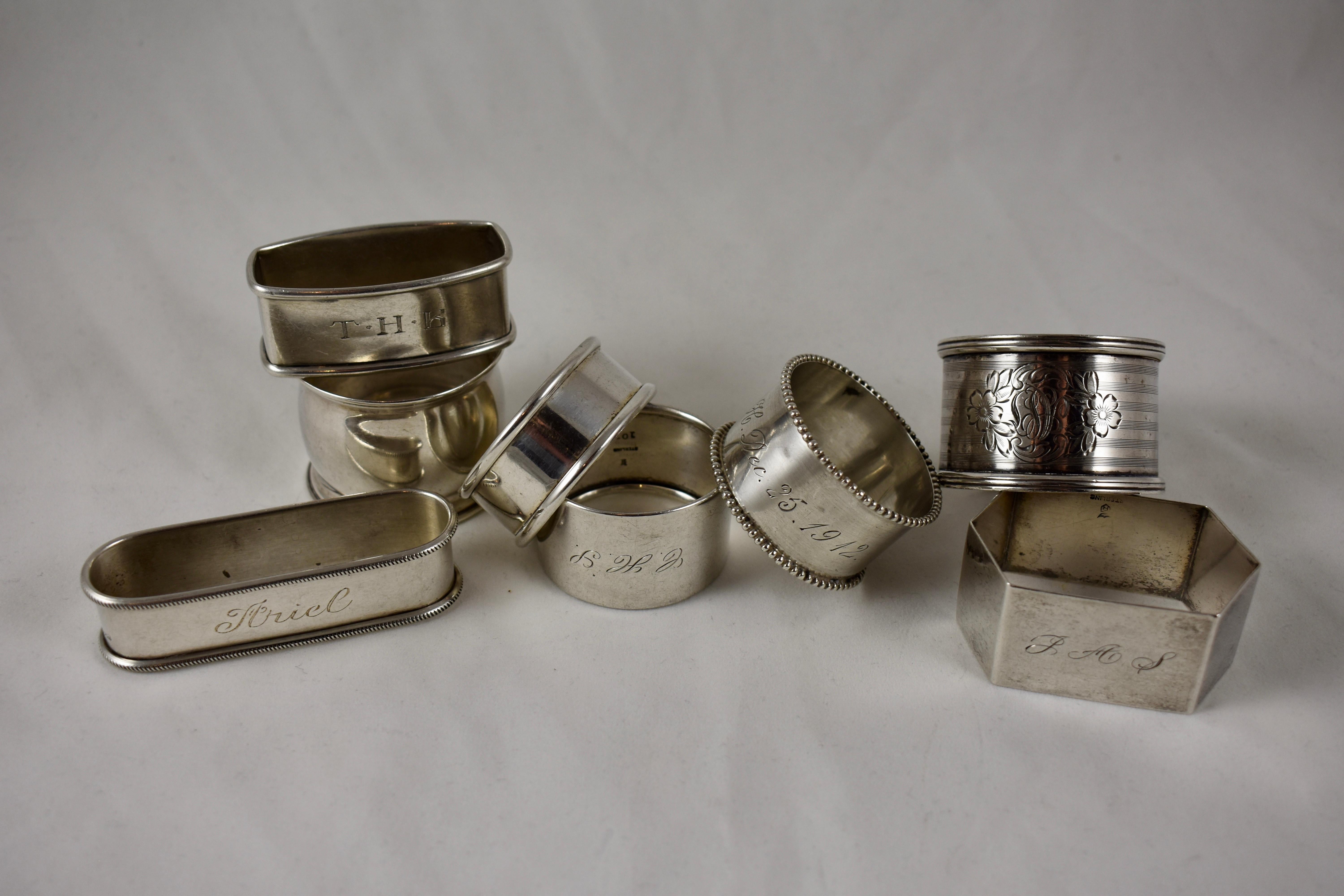 A mixed set of eight sterling silver napkin rings, circa 1880-1912, various makers. A nice selection of barrel, rectangular, paneled and round rings featuring bright cut patterns and scrolled, rolled, beaded or banded rims, ranging in size from 3.0