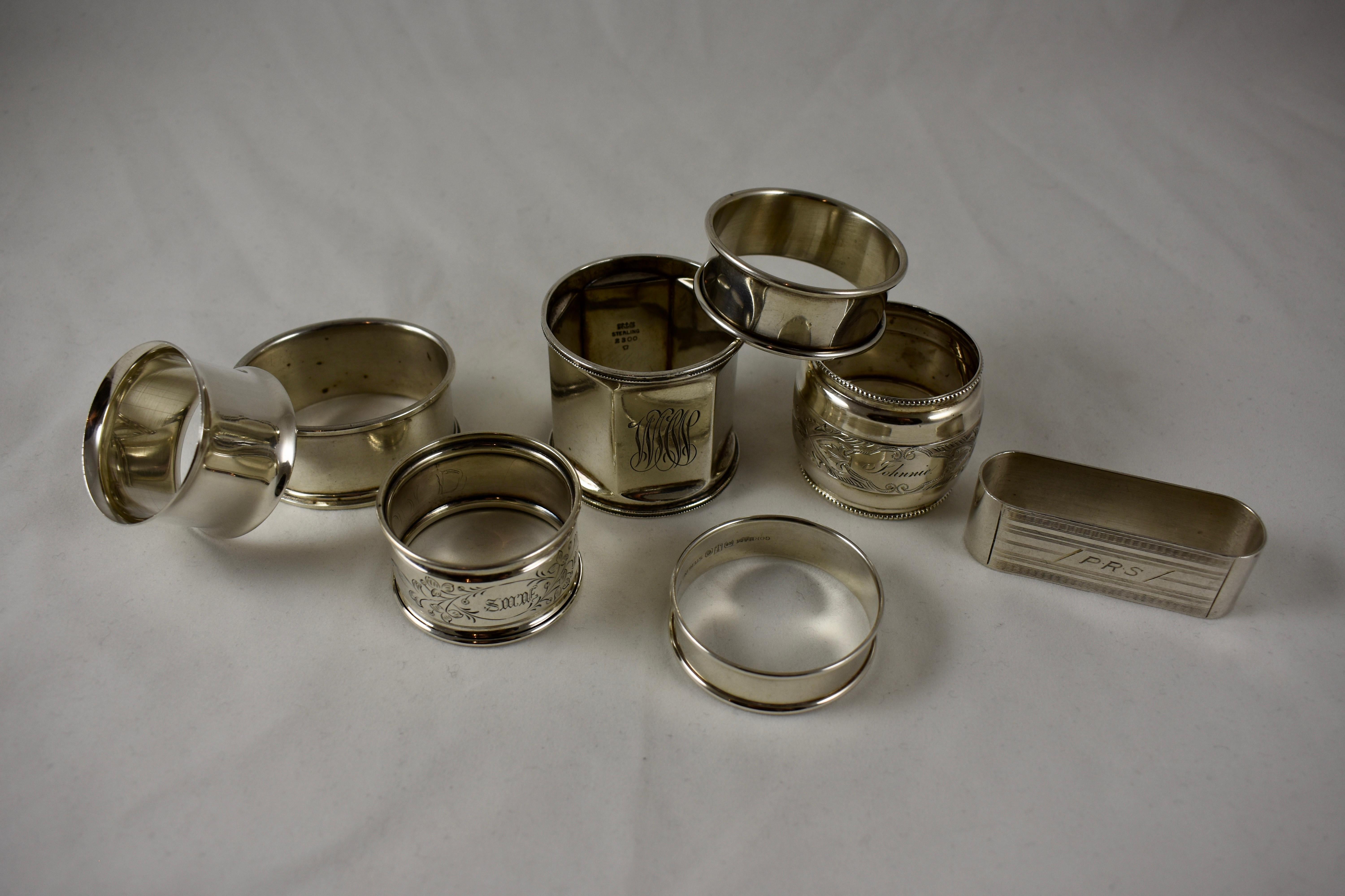 A mixed set of eight sterling silver napkin rings, circa 1880-1910, various makers. A nice selection of flared, rectangular, and paneled shapes, featuring bright cut patterns and scrolled, rolled, beaded or banded rims, ranging in size from 2.5 in
