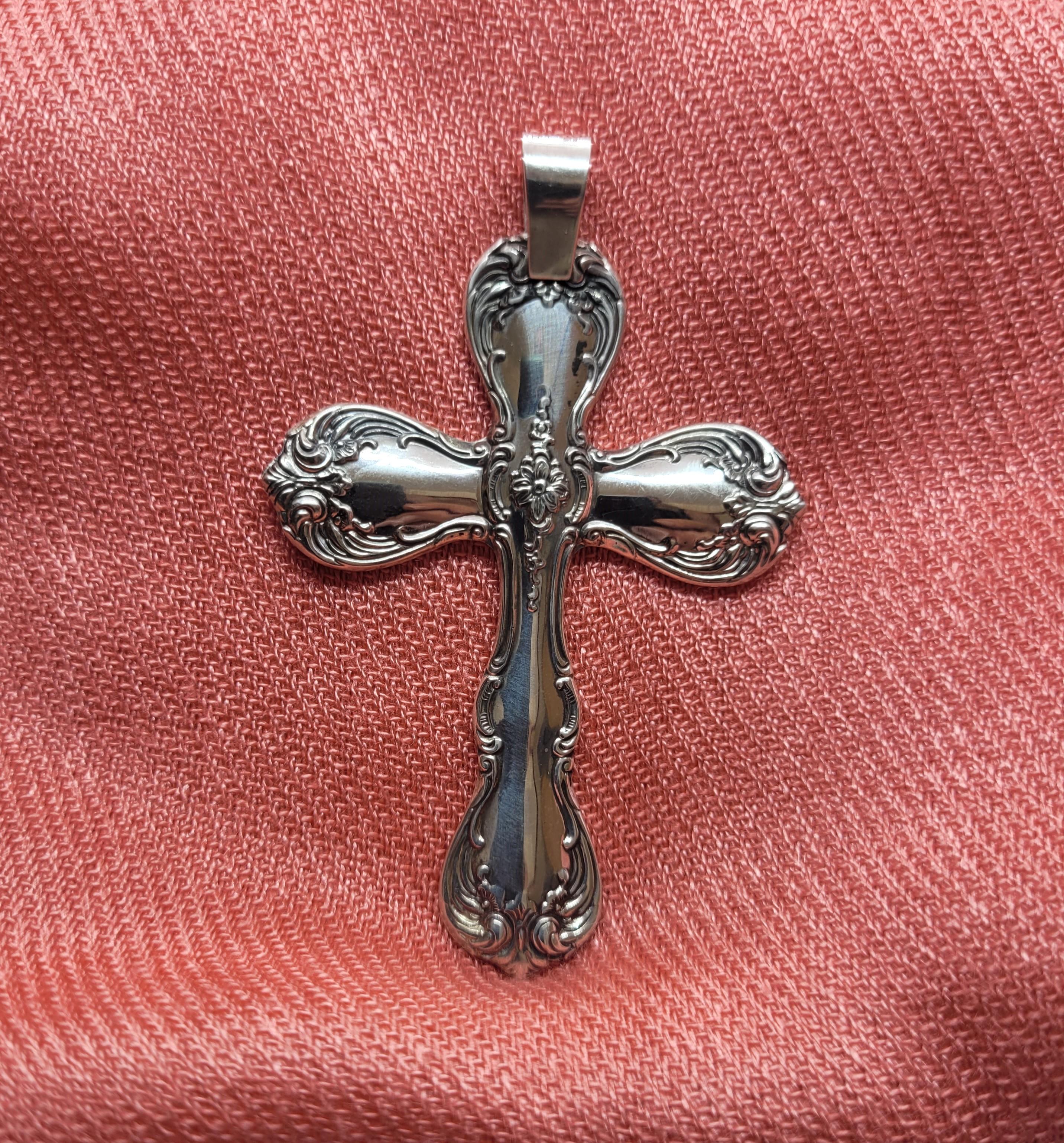 A unique sterling silver cross pendant that is made of antique sterling silver spoons by Towle Sterling featuring a lovely floral scroll design. This pendant is in very good condition, 21.2 grams, and 45.4mm x 63.15mm x 2.89mm in size (without the