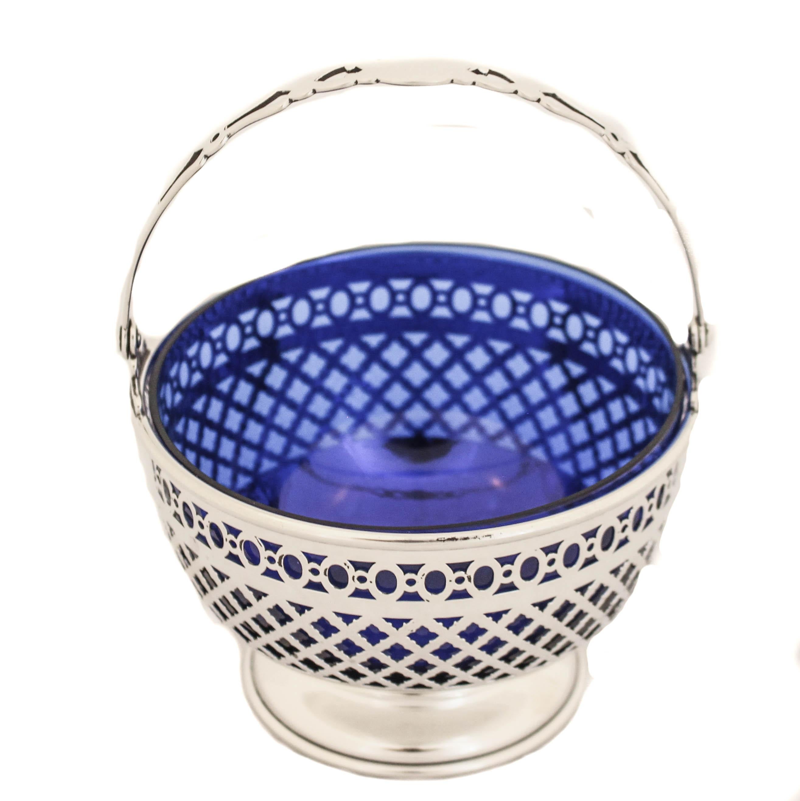 Being offered is a sterling silver basket with a cobalt liner manufactured by Gorham Silversmiths and retailed by Shreve, Crump & Low.  The sterling silver is reticulated so the cobalt glass shows through and gives a dramatic appearance.  The cutout