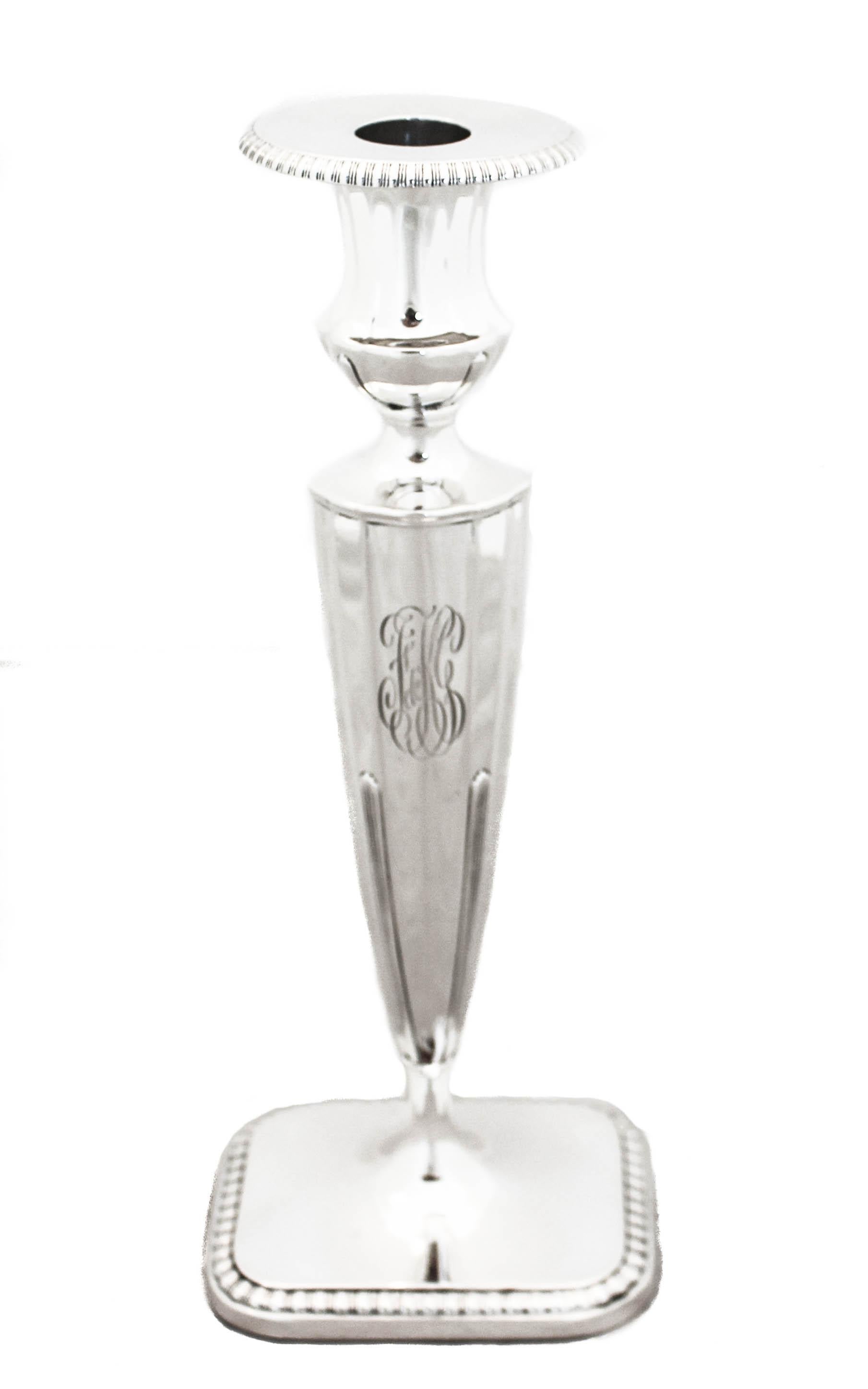 We are happy to offer you this pair of sterling silver Art Deco candlesticks by Reed and Barton. They are simply gorgeous! The base is oblong with a gadroon design around the edge and the same pattern is found around the bobeche. The body is tapered