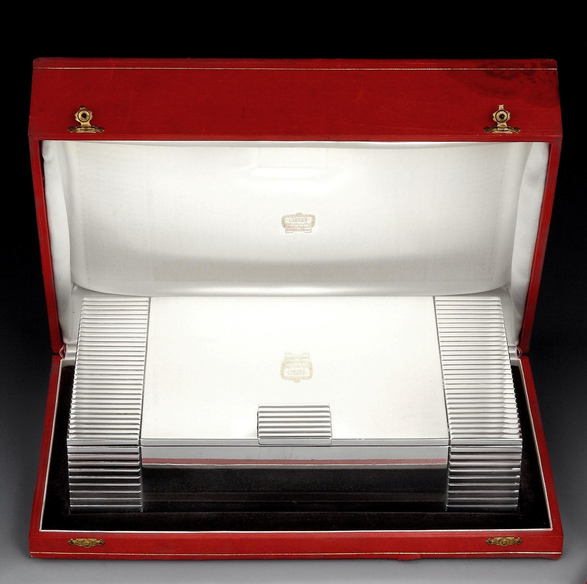 Cartier, Paris

A magnificent and generous sterling silver Art Deco cigar box of rectangular form, with a thick reeded border left and right, and a similarly designed thumbpiece. The interior of the box is cedar lined with a single, central