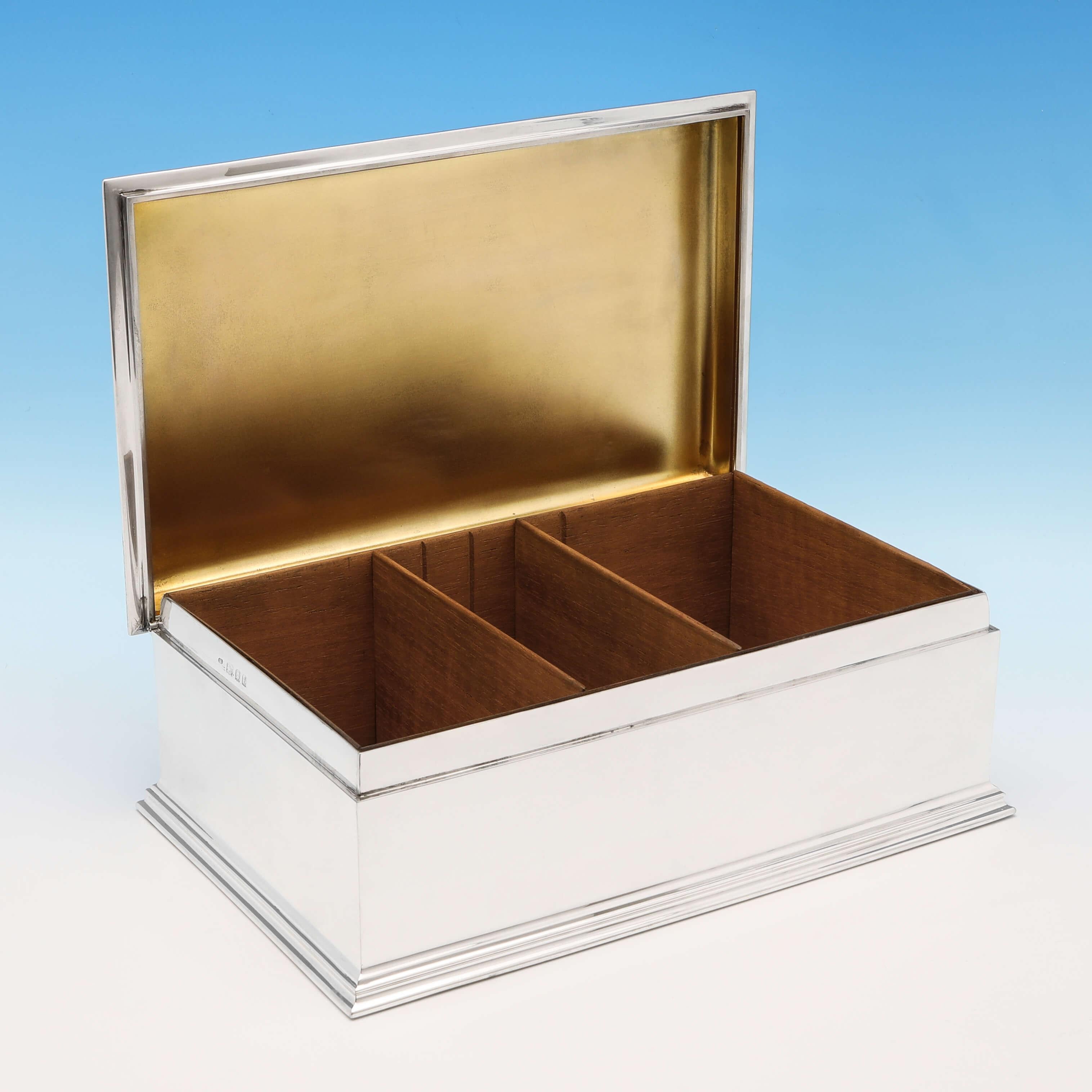 Hallmarked in London in 1921 by Charles Dumenil, this handsome, Art Deco, sterling silver cigar box, is plain in style, featuring a stepped base, reed borders, and a cedar lined interior. The cigar box measures: 4.25