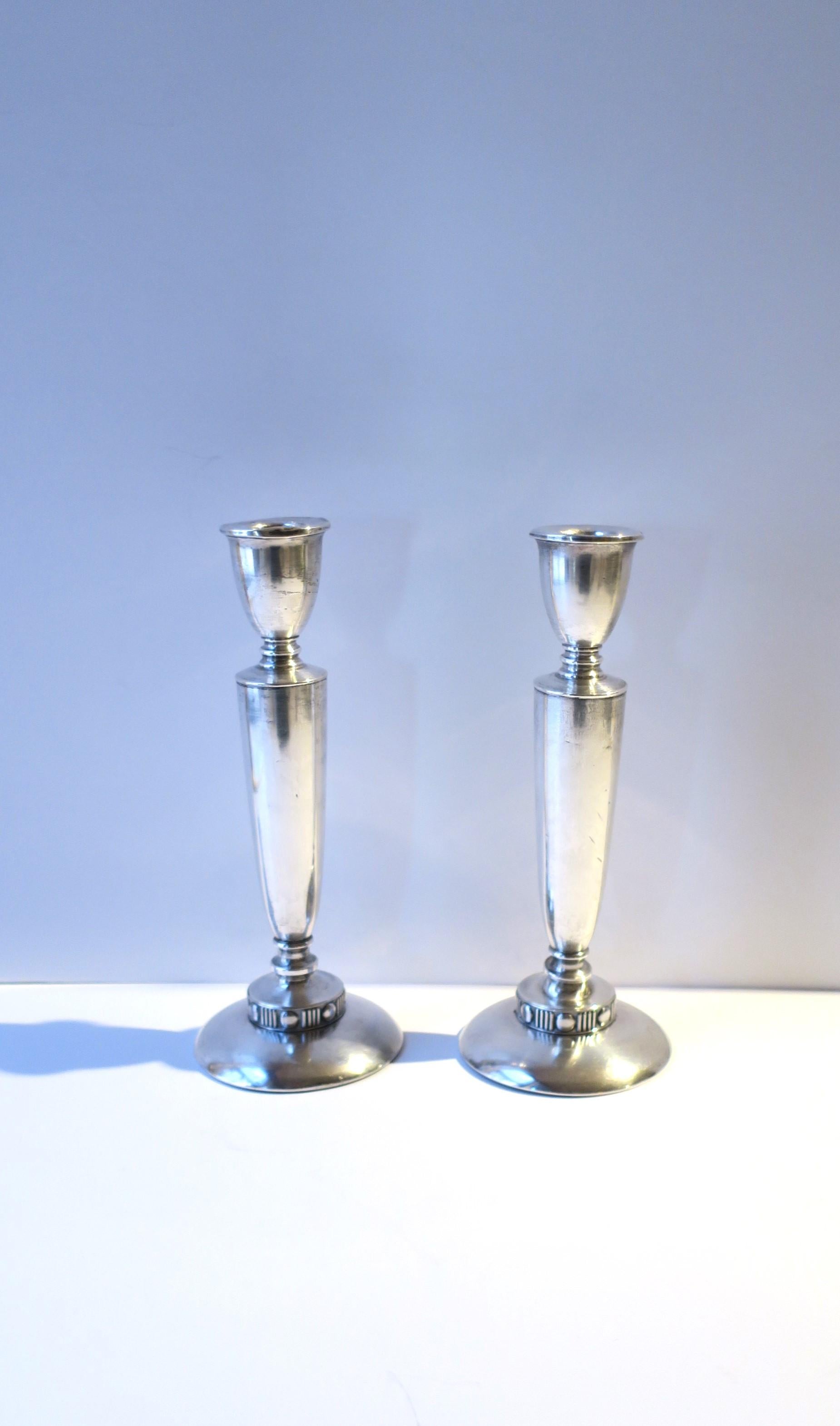 A pair of sterling silver candlestick holders, Art Deco period, circa early-20th century, New York, USA. Pair are strong and well made. Marked 'Sterling' on bottom of both as shown in last two images. Dimensions: 3.88