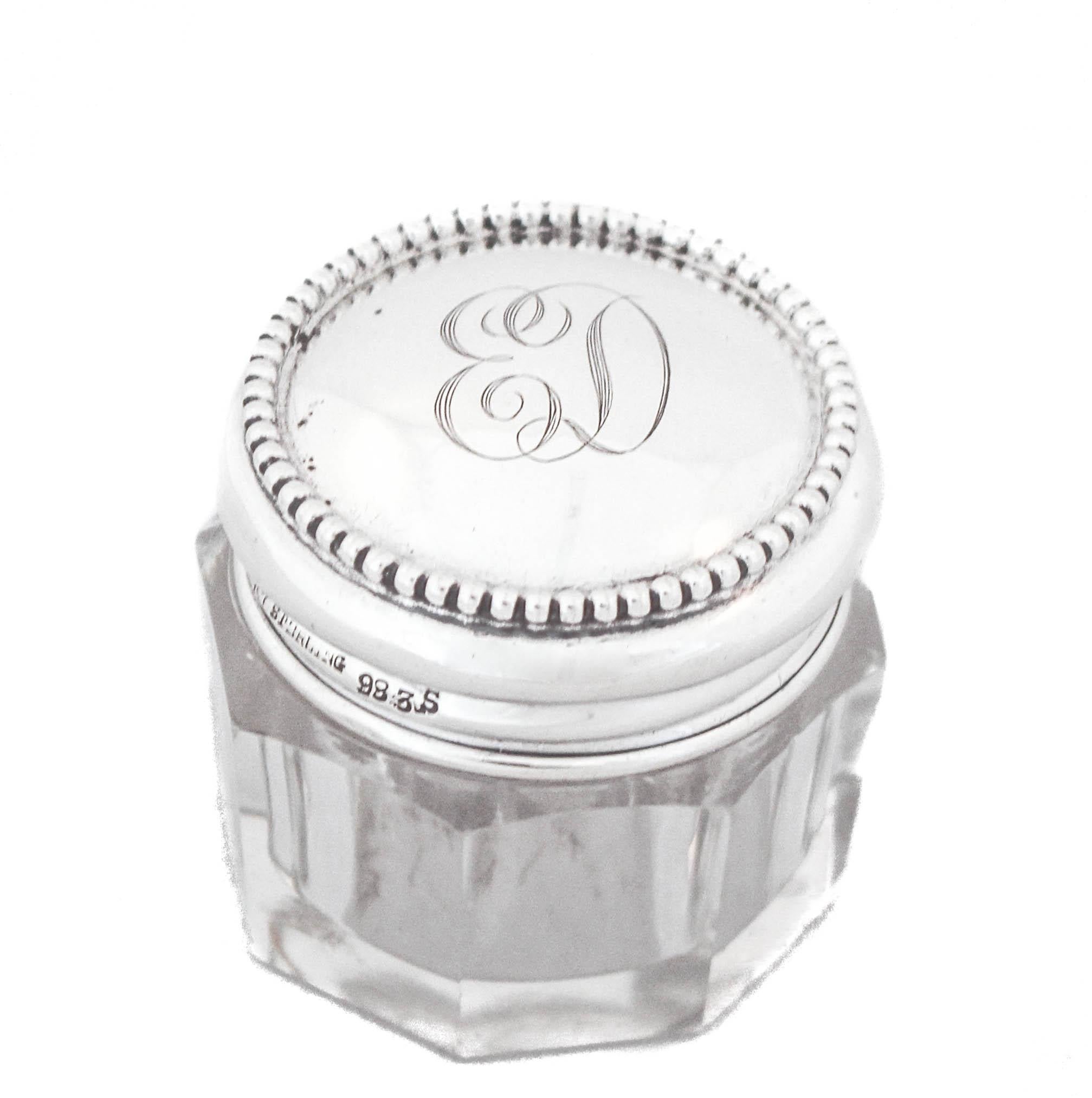 Being offered is a sterling silver and crystal vanity jar.  The silver cover has a row of beading around the rim — very common in Art Deco designs.  The crystal jar is paneled rather than a single round shape— again common in Art Deco design.  These