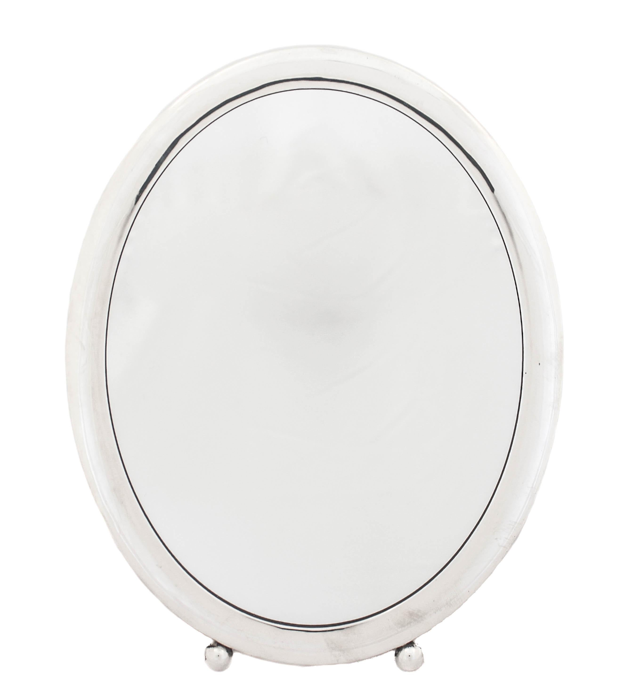 We are happy to offer you this sterling silver Art Deco vanity mirror. It’s the perfect size for you vanity table — not too big and definitely not too small. Notice the shape and the two balls on the bottom, very Art Deco.