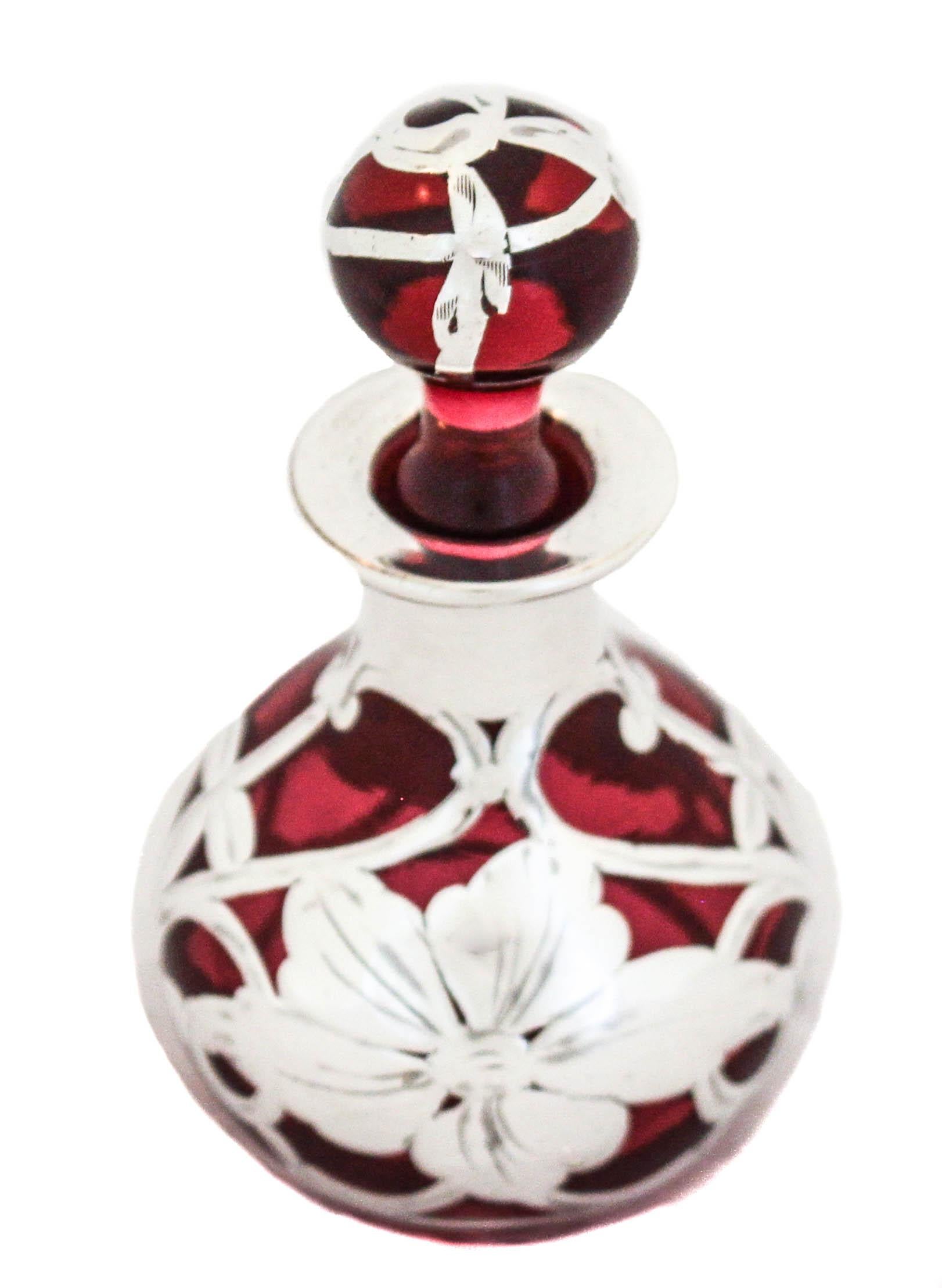 Being offered is a sterling silver and crystal perfume bottle from the Art Nouveau period.  It has a ruby-red glass with sterling overlay.  The silver pattern is quintessential Art Nouveau in its’ style of flowers and swirls.  The color is so rich