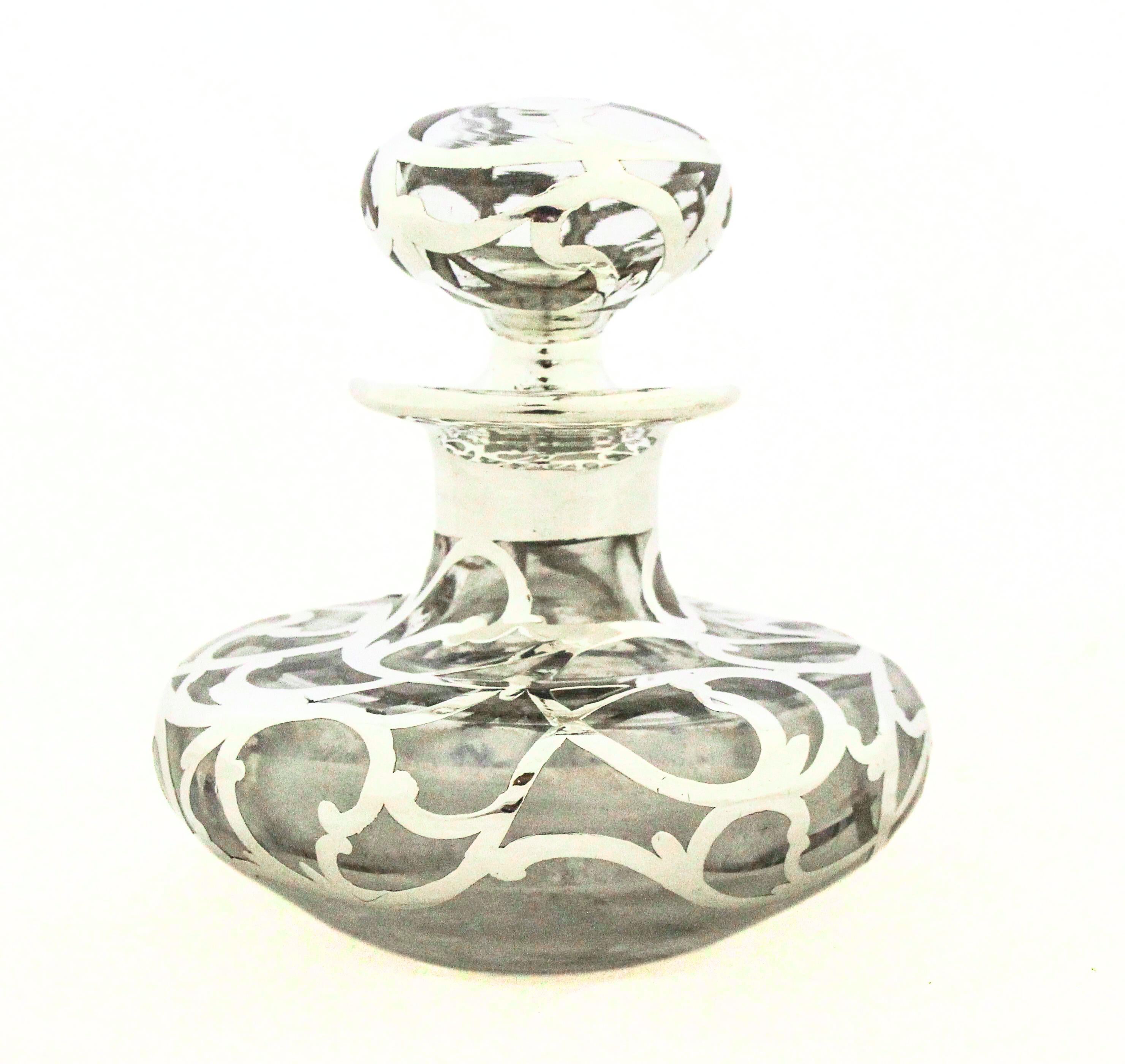 Step into the elegant world of Art Nouveau with this stunning sterling silver overlay perfume bottle, a masterful fusion of intricate filigree craftsmanship and subtle opulence. Dating to the early 20th century, this piece embodies the movement’s