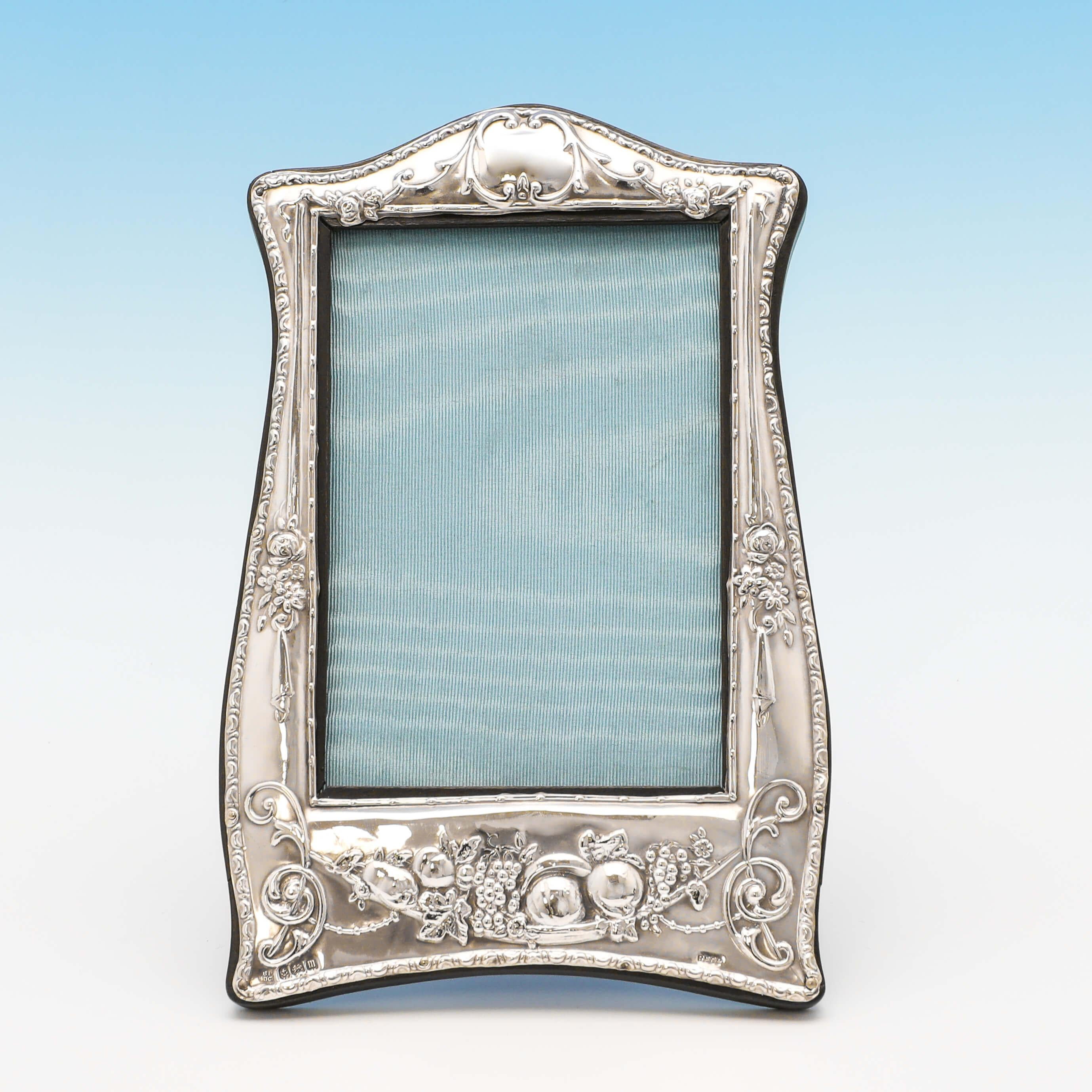 Hallmarked in Birmingham in 1911 by Boots Pure Drug Co., this attractive, antique sterling silver photograph frame, is in the Art Nouveau taste, and features a wooden easel back. The photograph frame measures: 8