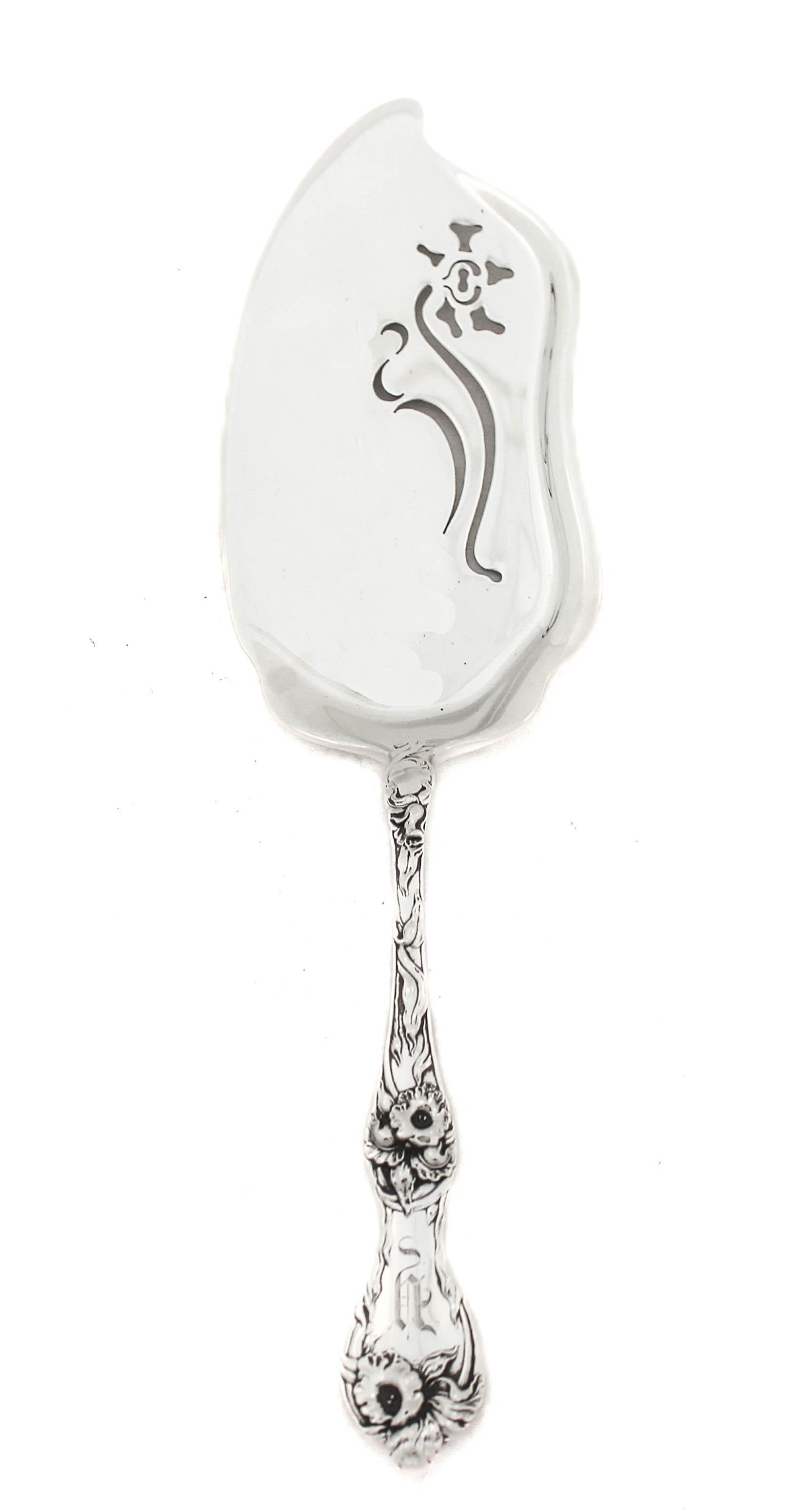 Being offered is a sterling silver Art Nouveau server by Reed and Barton.  The handle has flowers and leaves in an organic “free-flowing” motif.  This is quintessential Art Nouveau; inspired by nature’s beauty.  The server is scalloped and has a