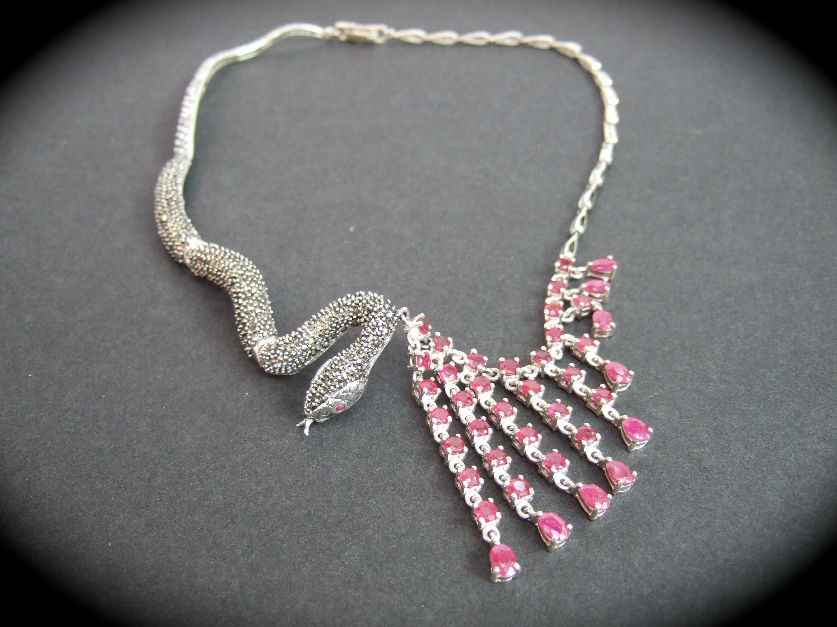 Collana artigianale in argento 925 con granato marcasite articolato 21° secolo
Questa collana artigianale unica nel suo genere è disegnata con un serpente sinuoso e articolato.
incrostato di marcasiti scintillanti

Da un lato pendono file di