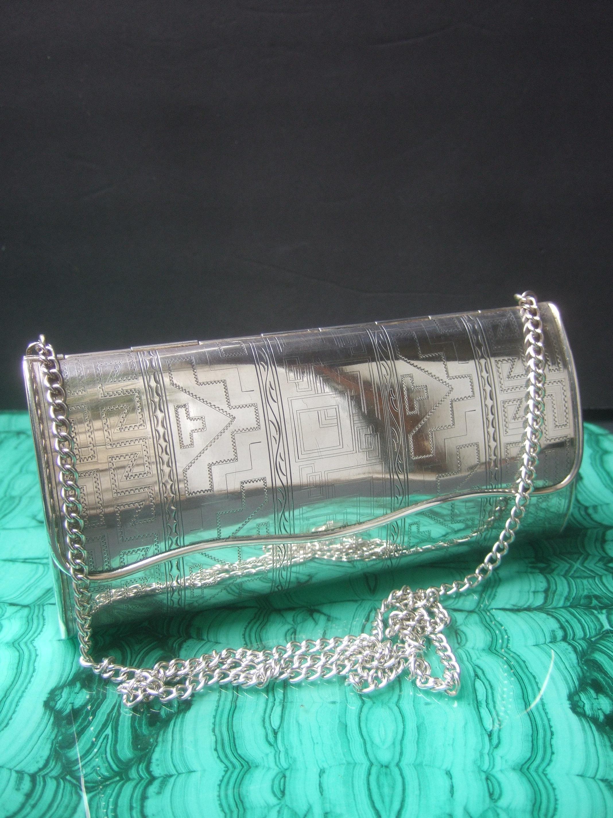 Opulent sterling silver artisan minaudiere' evening bag c 1970s
The exquisite sterling silver minaudiere' is embellished with intricate subtle geometric impressed designs on the exterior

The elongated oval-shaped sides in contrast are smooth shiny