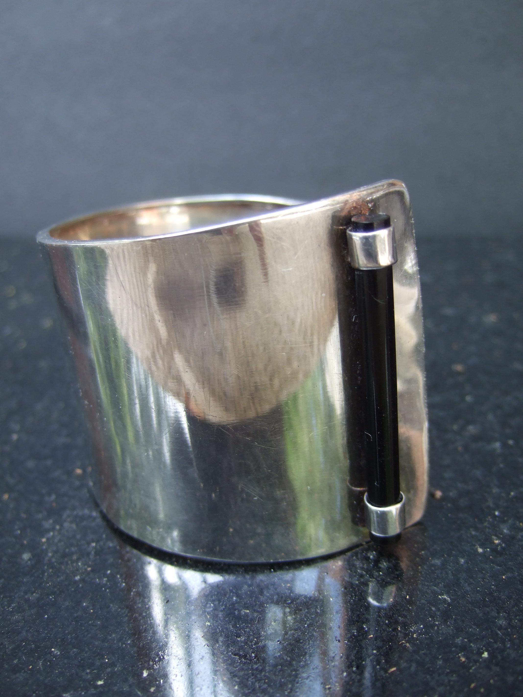 Sterling silver wide handmade artisan cuff bracelet. The unique bracelet is constructed with a wide sterling band that gradually widens on one end. Designed with a thin black lucite cylinder rod soldered on the widest end.
The severe bold unisex