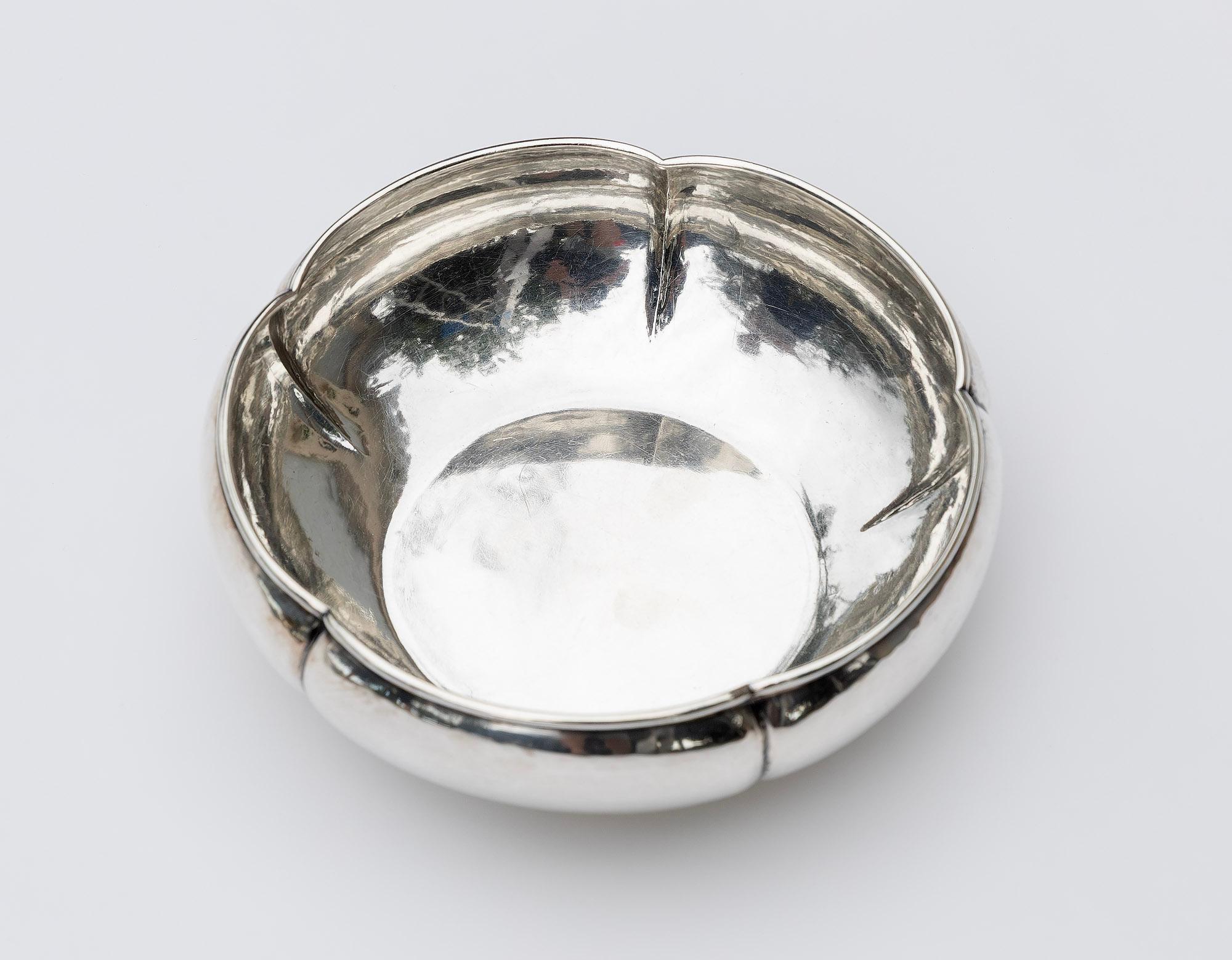 Die handgehämmerte Schale aus Sterlingsilber von Kalo Shop hat eine geschwungene Form und ist im Arts-and-Crafts-Stil gehalten. Sie trägt die Nummer 18. Er hat einen gewellten Rand mit elegant geschwungenen Lappen. Sie hat eine sanft gehämmerte