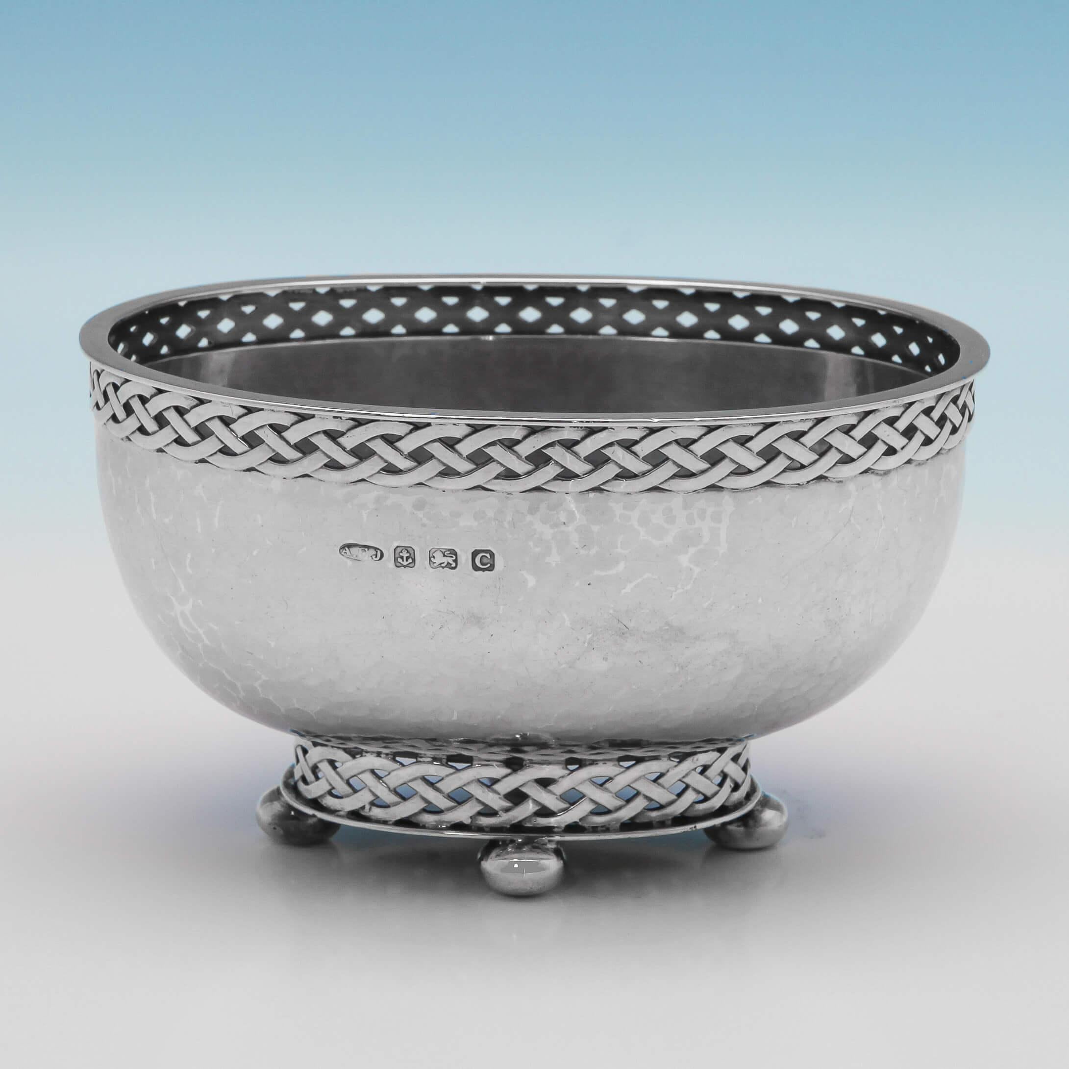 Hallmarked in Birmingham in 1927 by A. E. Jones, this charming, Sterling Silver, Arts & Crafts Bowl features a hand-hammered oval body, ball feet and Celtic Knot pierced borders around the base and rim. The bowl measures 3
