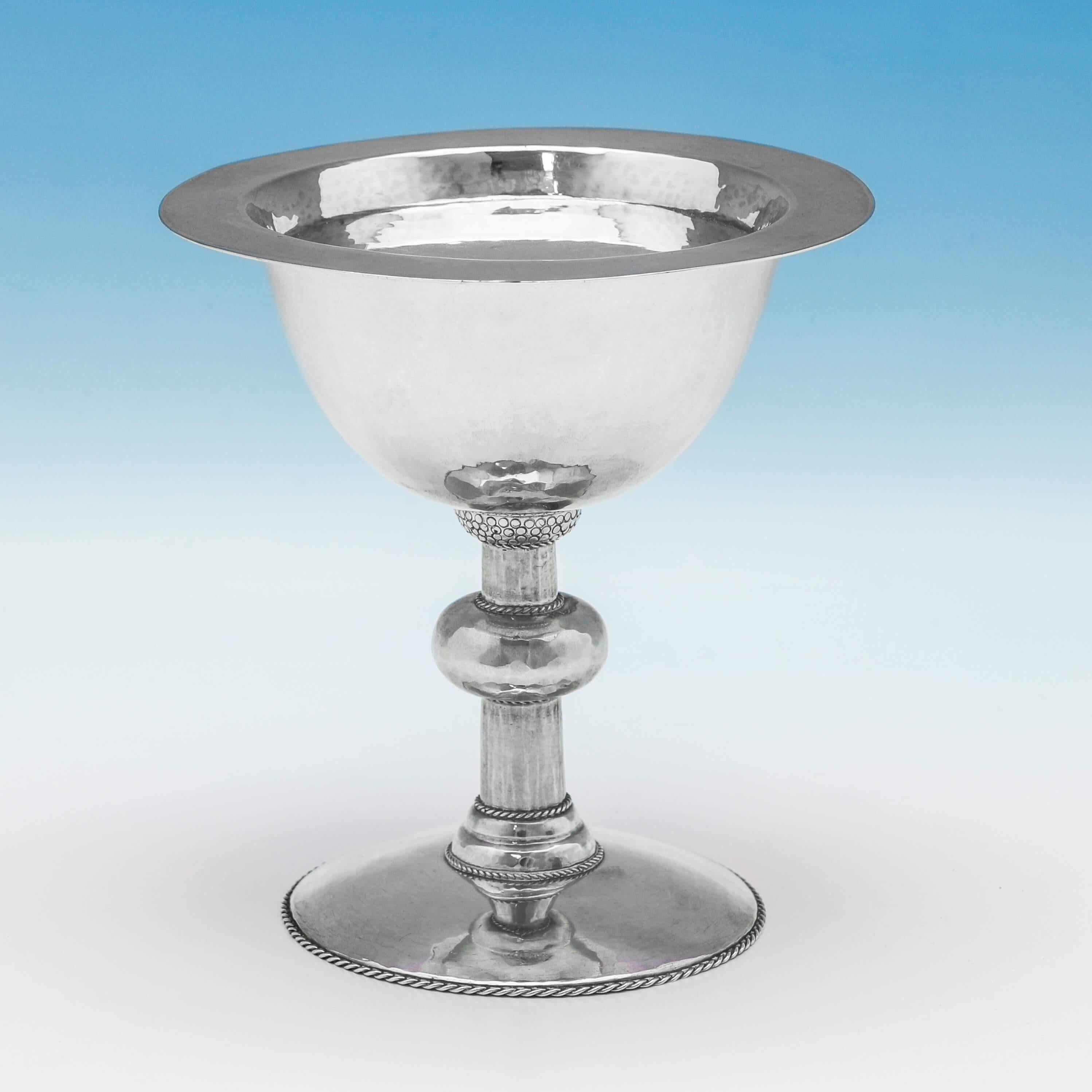 Hallmarked in London in 1924 by Artificers Guild, this beautifully crafted, hand-hammered, sterling silver chalice and paten, features fine twist rope borders on the chalice, while the paten is plain in design. The set is presented in its original,