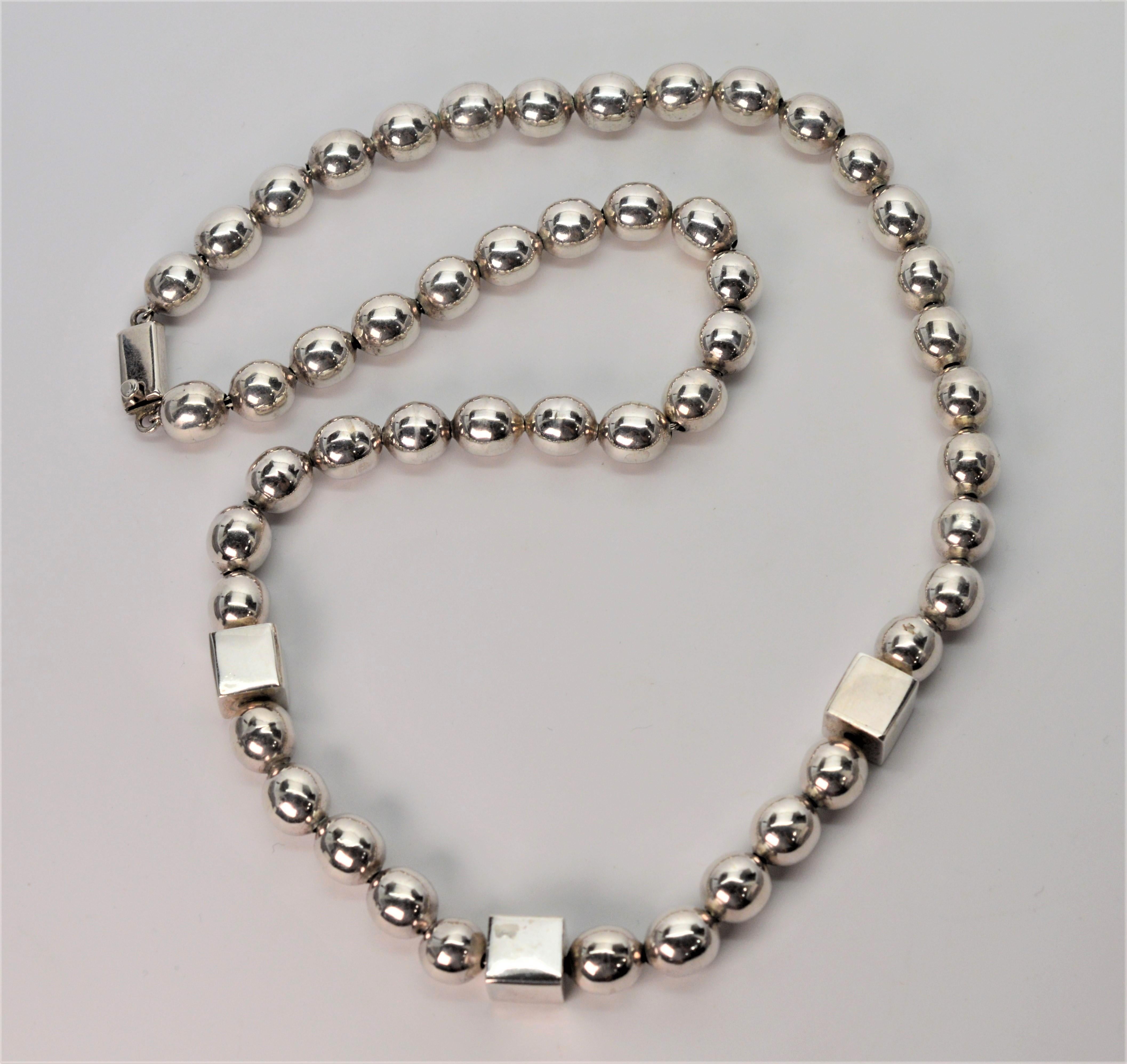 Bold, thick-bodied Sterling Silver Ball Chain Necklace crafted in Mexico of .925  Sterling Silver. Fifty round 10mm silver beads are accented with three featured square beads to give this relevant piece dimension. Twenty five inches in length with