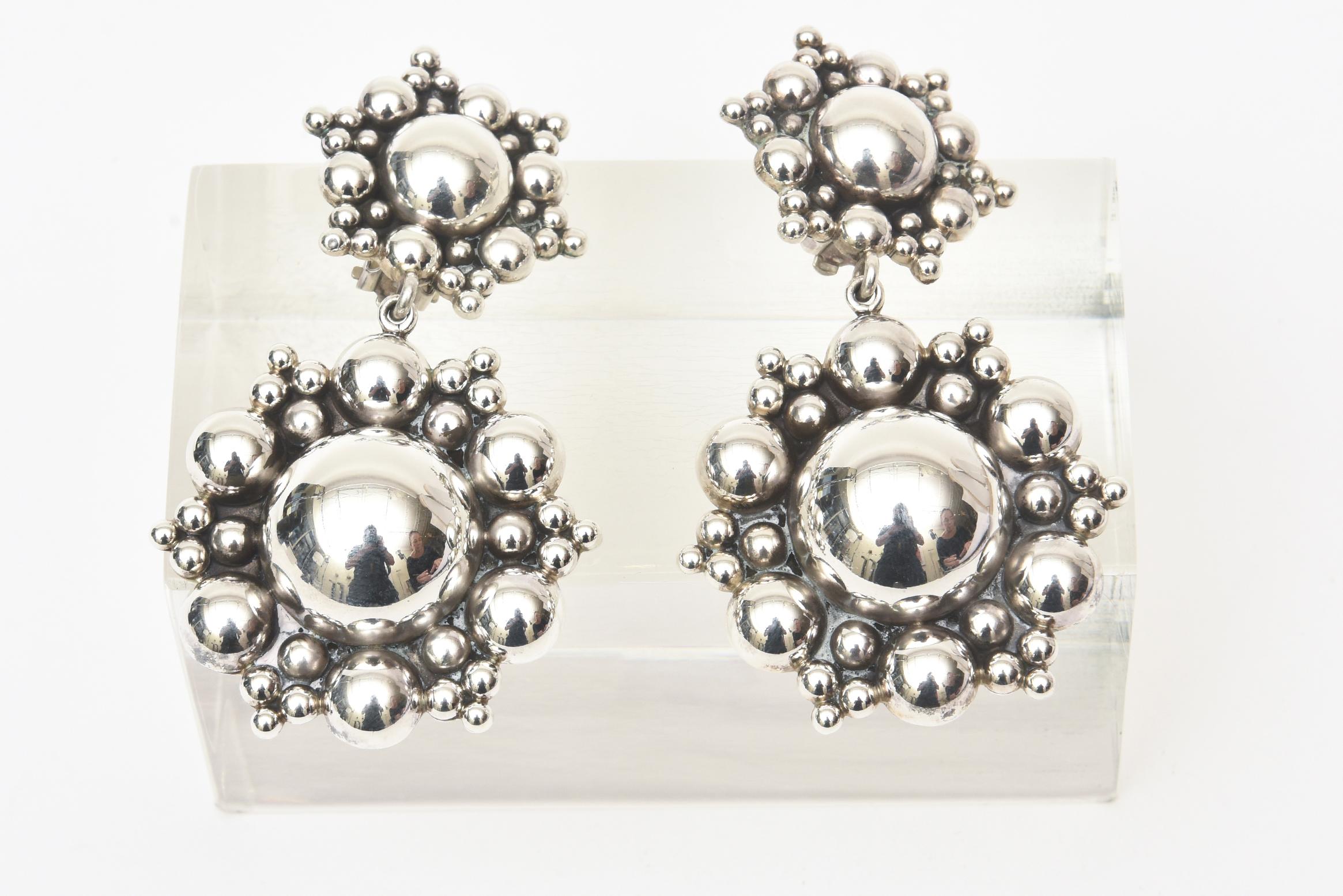 These stunning and dramatic never worn sterling silver dangle clip on earrings were originally from Neiman Marcus from the 80's. They have a great presence and will be a statement on your ears. They have a great cluster ball form at the top and