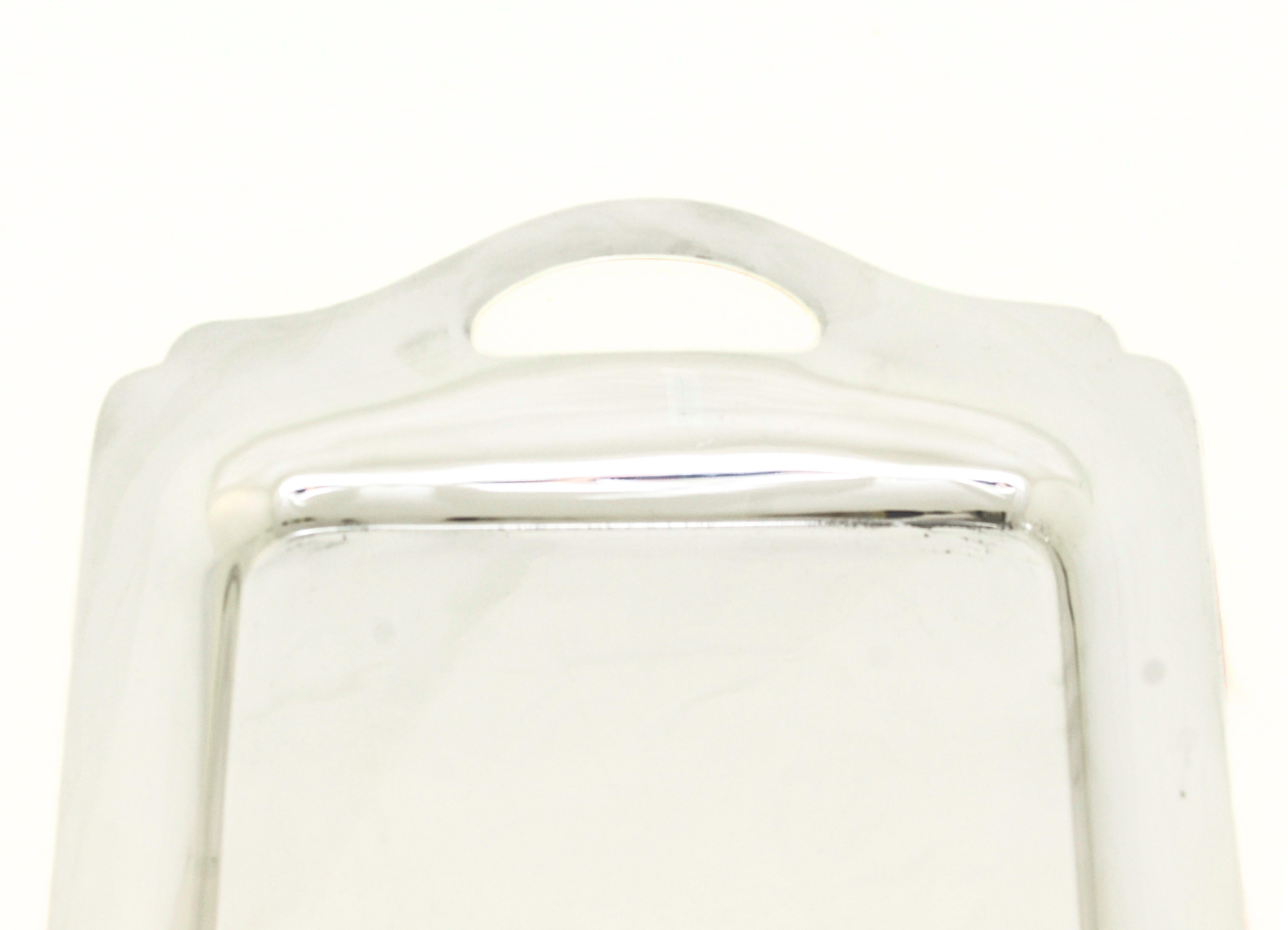 This impressive sterling silver serving tray by Wallace Silversmiths exemplifies timeless sophistication and modern simplicity. Measuring an elegant 27 inches long by 12 inches wide, it features a sleek, unadorned surface that highlights the beauty