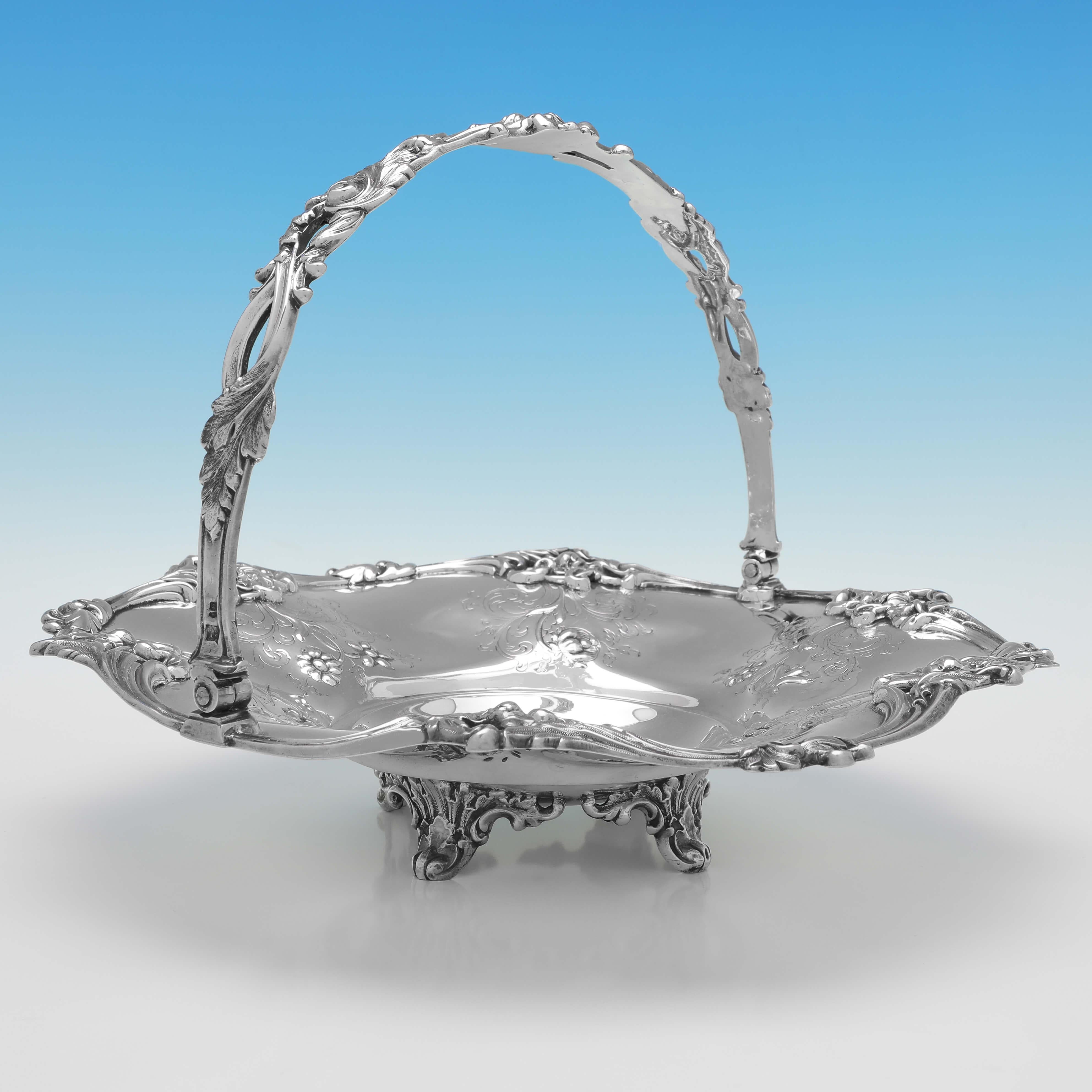 Marcada en Londres en 1854 por Joseph & Albert Savory, esta encantadora cesta victoriana de plata de ley antigua tiene forma redonda y presenta una decoración floral grabada y cincelada en el cuerpo, un borde floral fundido y aplicado y un asa
