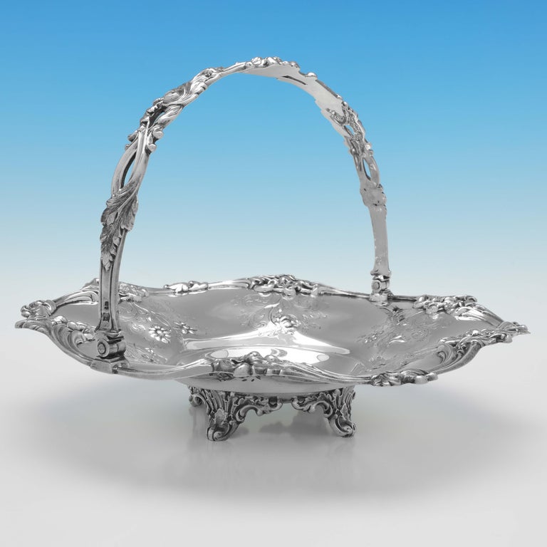 Hallmarked in London in 1854 by Joseph & Albert Savory, this delightful, Victorian, antique sterling silver basket, its round in shape, and features floral chased and engraved decoration to the body, a cast and applied floral border and a swing