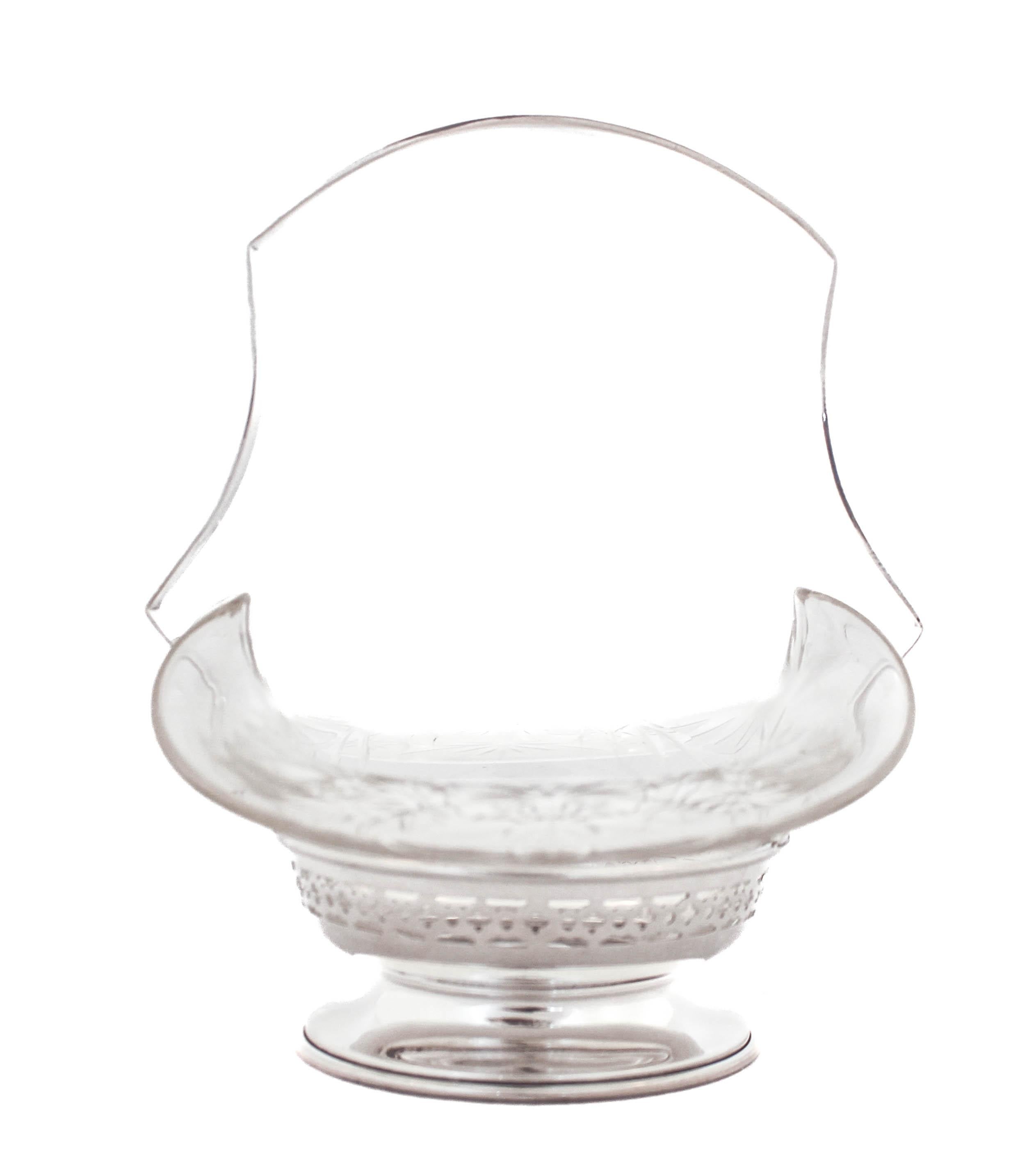 Being offered is a sterling silver basket with a crystal liner.  The sterling part has a reticulated design going around the top and the handle is stationary.  The glass liner fits in snug and conforms to the shape of the handle and has an etched
