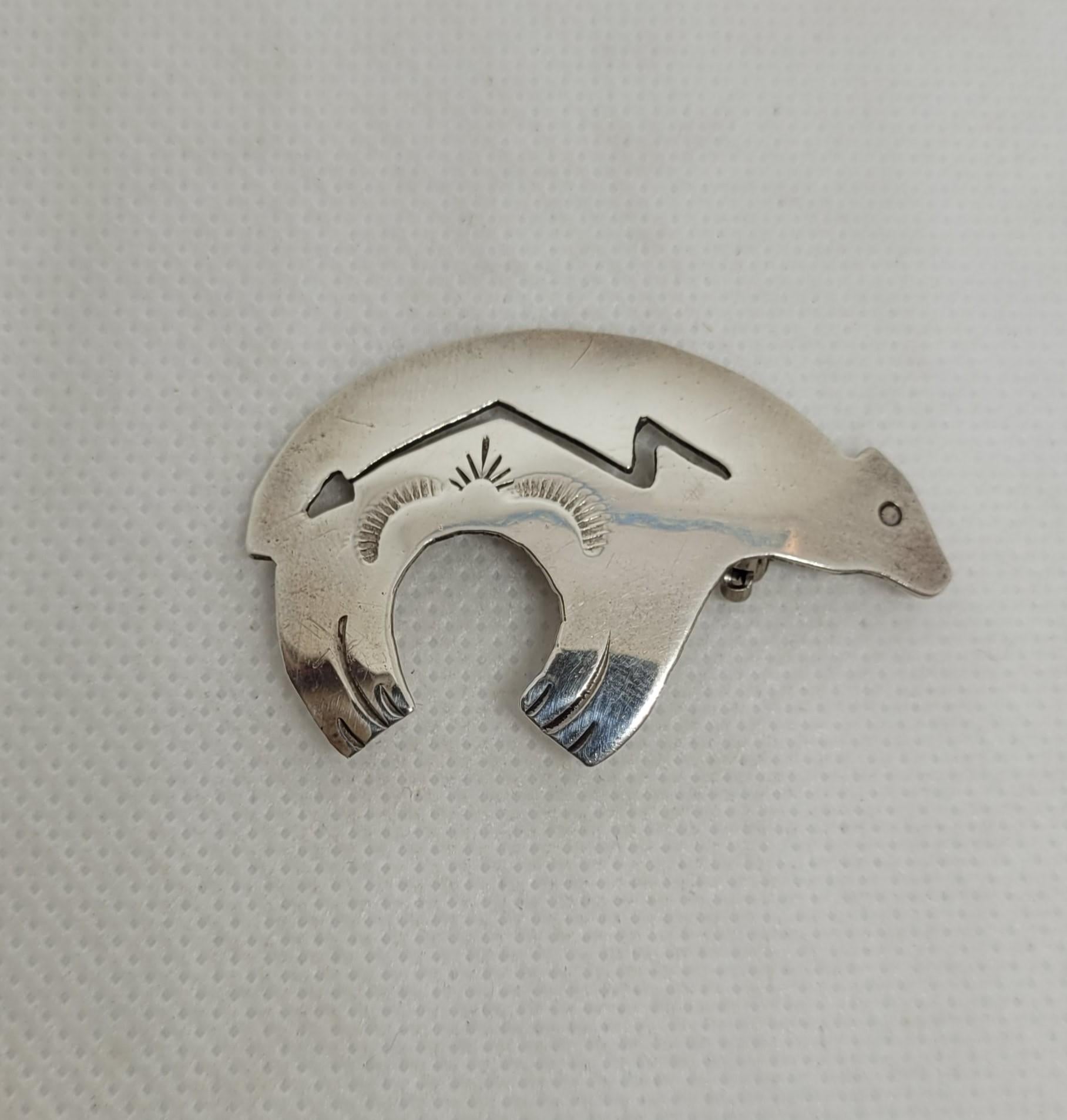 Beautiful sterling silver bear pin featuring an arrow, designed by the renowned Native American Navajo artist Harrison Bitsue. The pin weighs 5.1 grams and is stamped 
