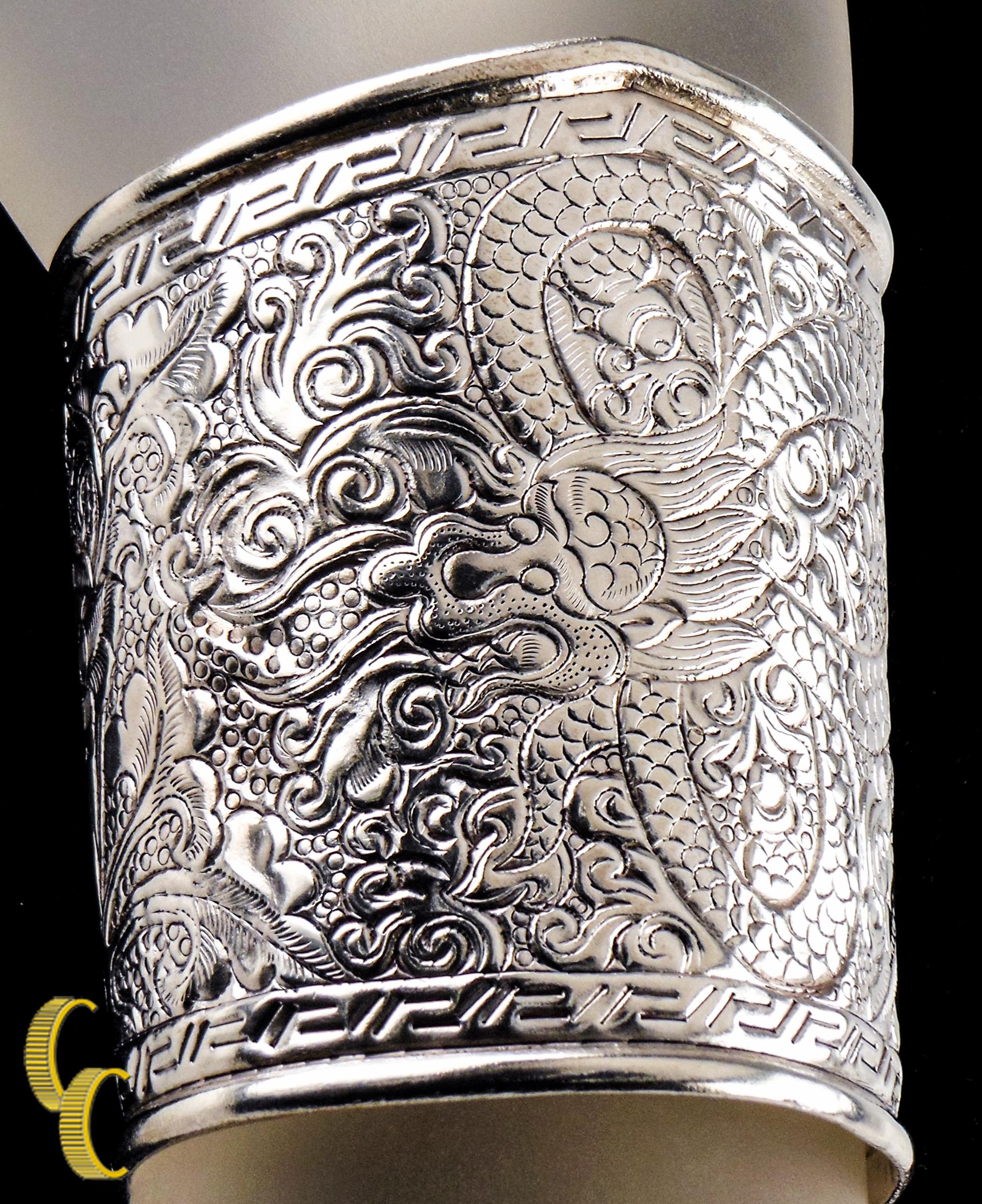 0.925 sterling silver cuff bracelet with a bearded dragon, flowers and leaves design.
Asian theme with dragon in the center and floral detailing.
A beautiful piece that is in excellent condition.
Wrist Fit: 5.5 inches.
Bracelet Width: 2 3/8 to 3