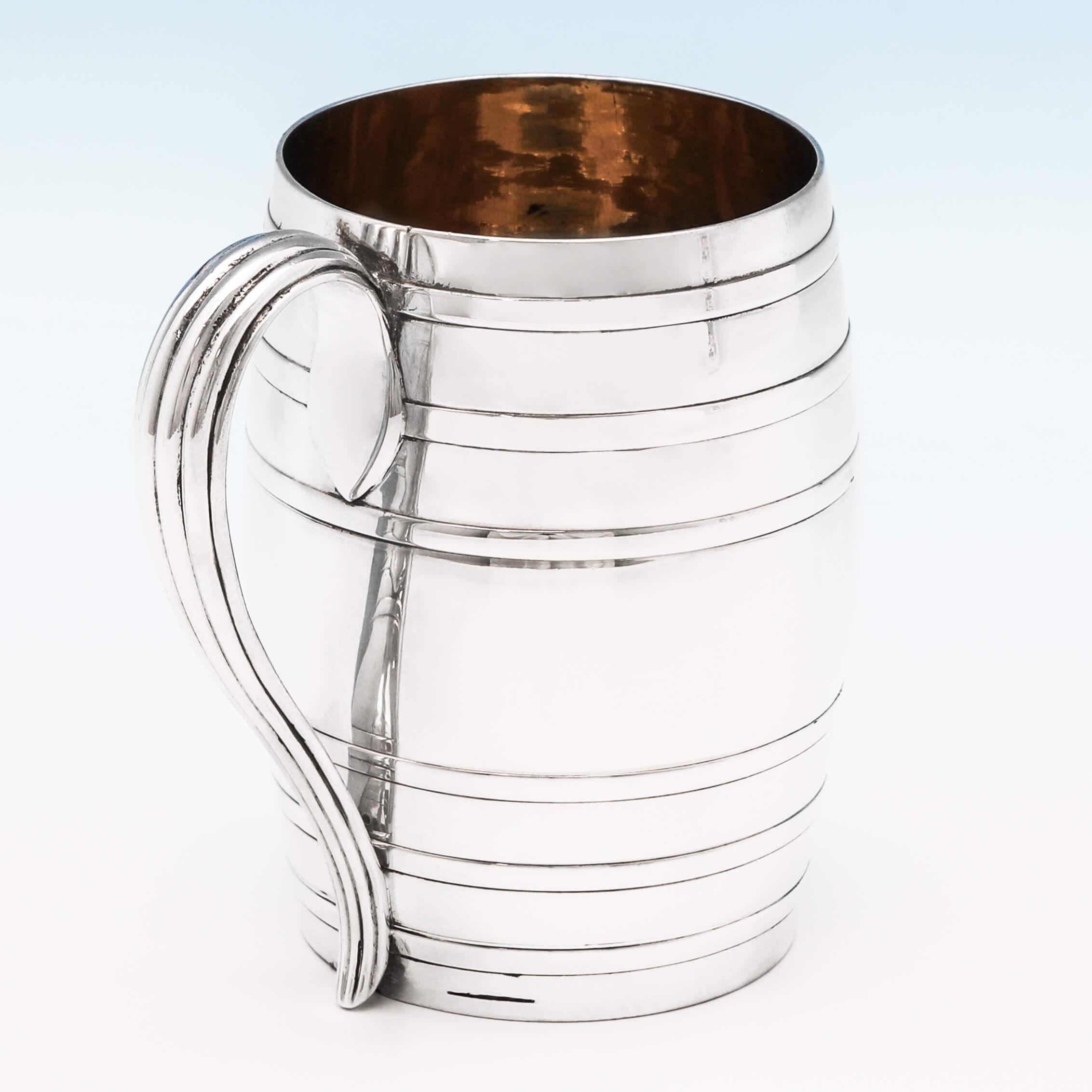 Hallmarked in London in 1778 by Lewis Pantin II, this handsome, George III, antique sterling silver mug, features a gilt interior, and is designed to look like a beer barrel. The mug measures 4