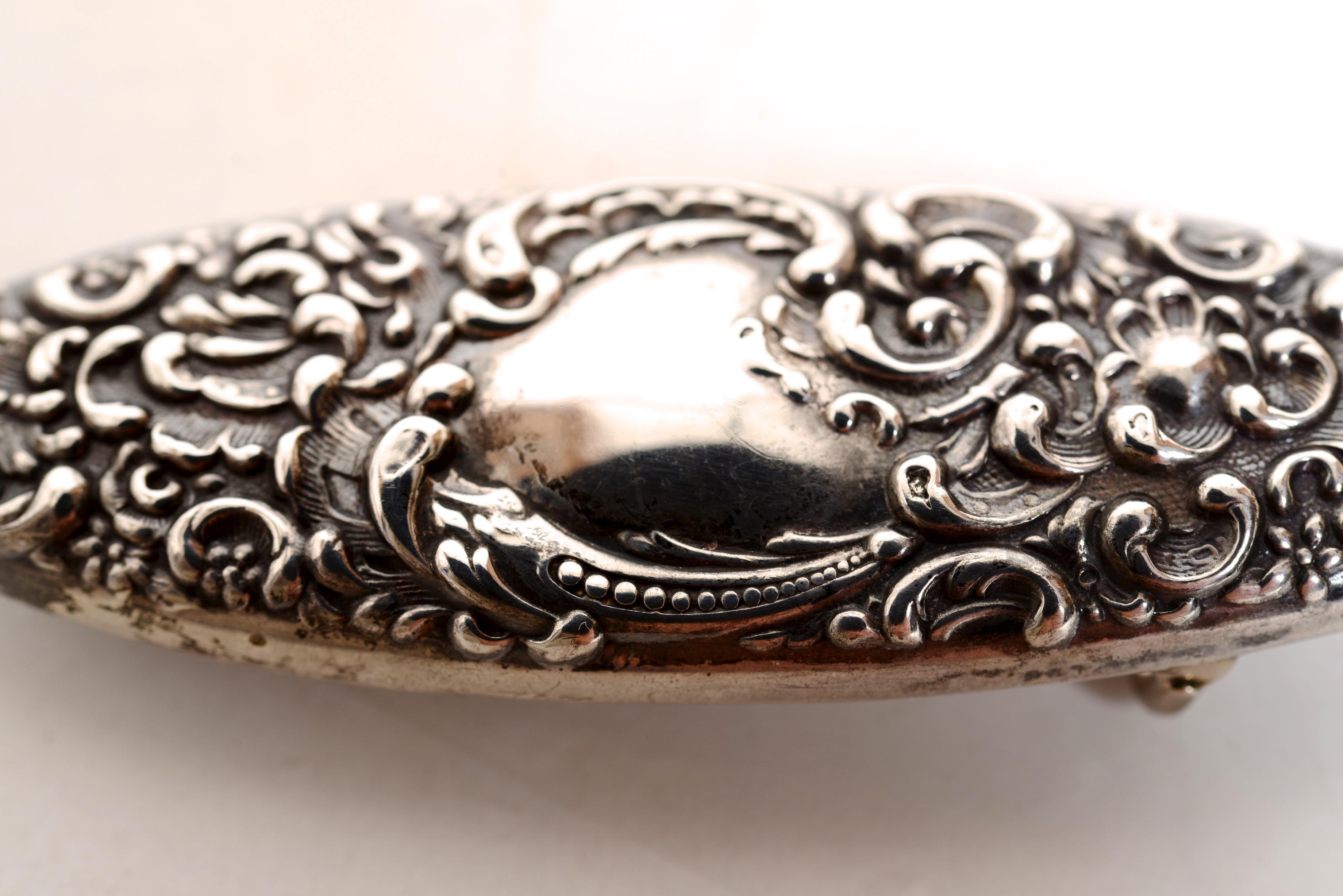 Sterling Silver Floral and Leaf Decorated Sash Belt Buckle, c1840. The design work of stylized flowers and shells is crisp and has a beautiful patina. The center has a place for initials but has never been engraved. The buckle is marked with a