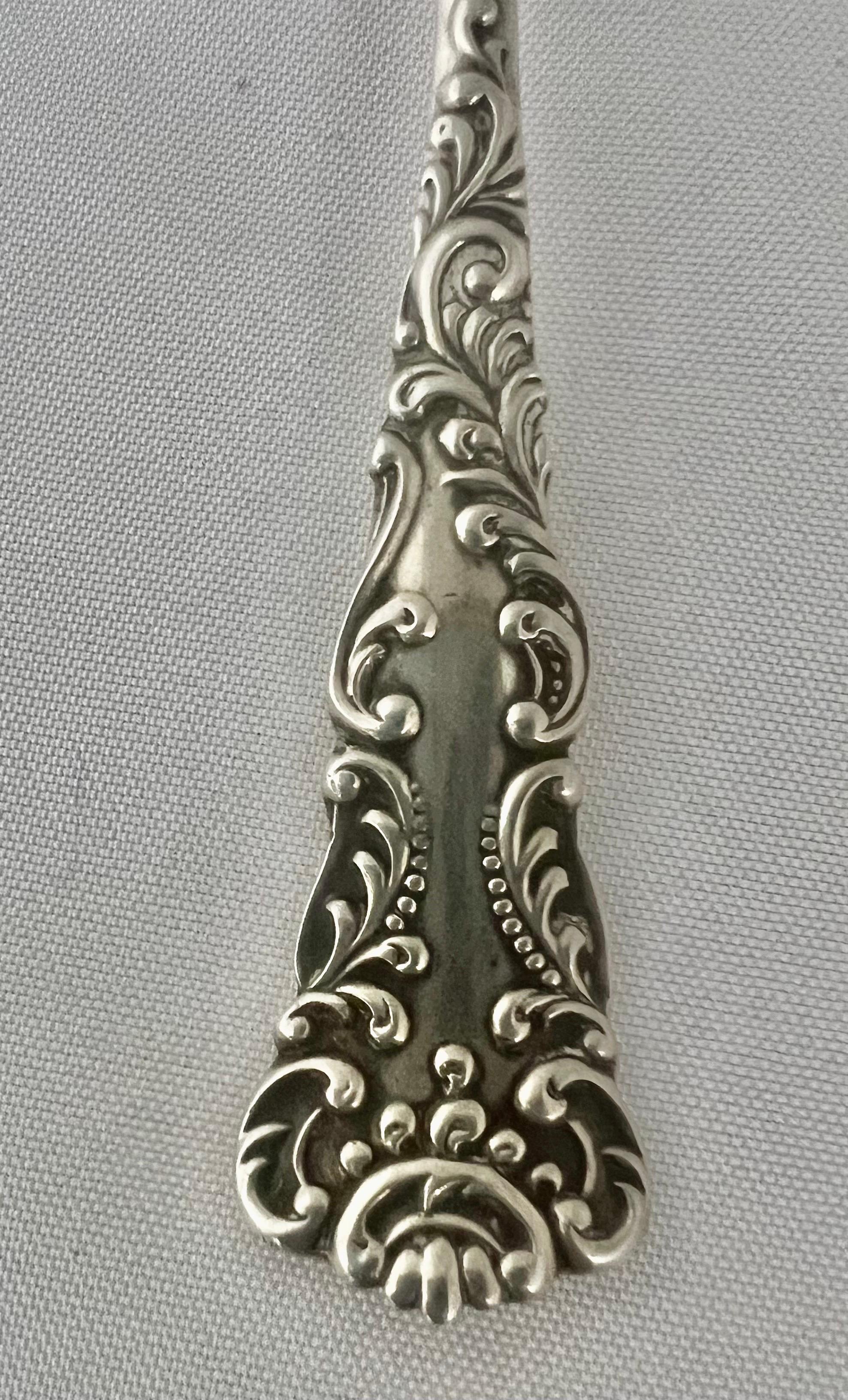 Ornate sterling silver berry spoon adorned with scrolled acanthus leaves.  A beautiful and intricate piece, perfect for elegant table settings or collector's of fine silver.